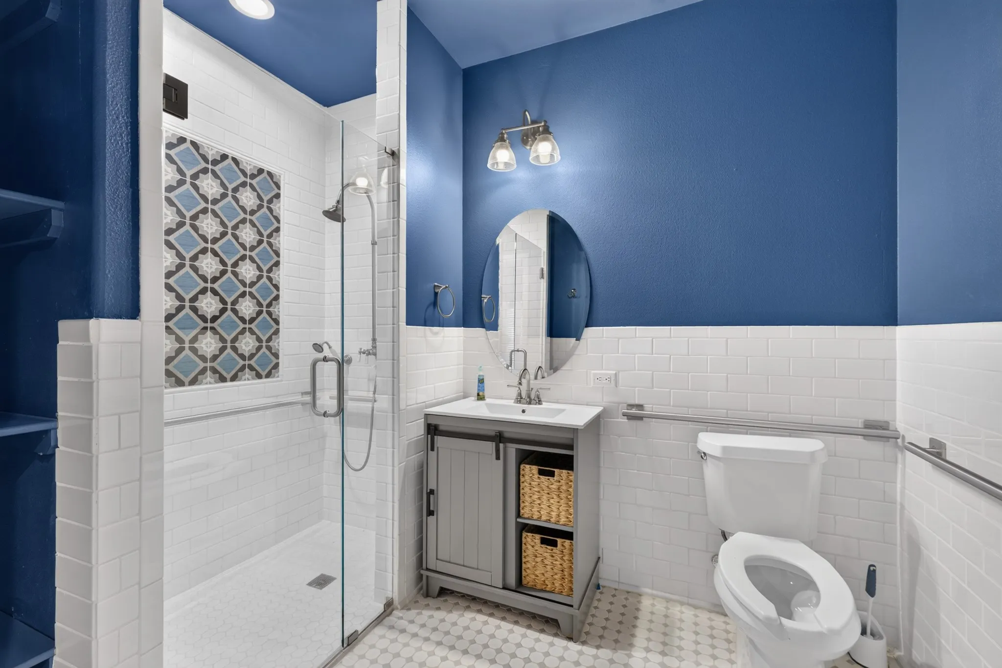 Walk-in shower with patterned tile accent, glass enclosure, and overhead recessed lighting