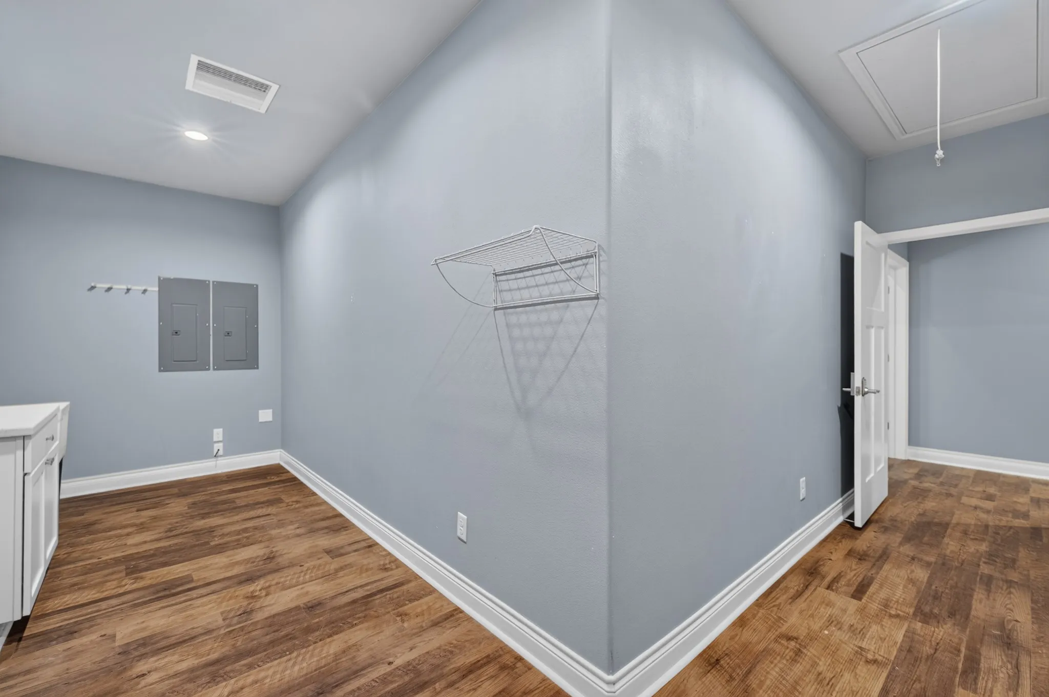 Wood-finish flooring, recessed lighting, white trim, and a built-in wire rack