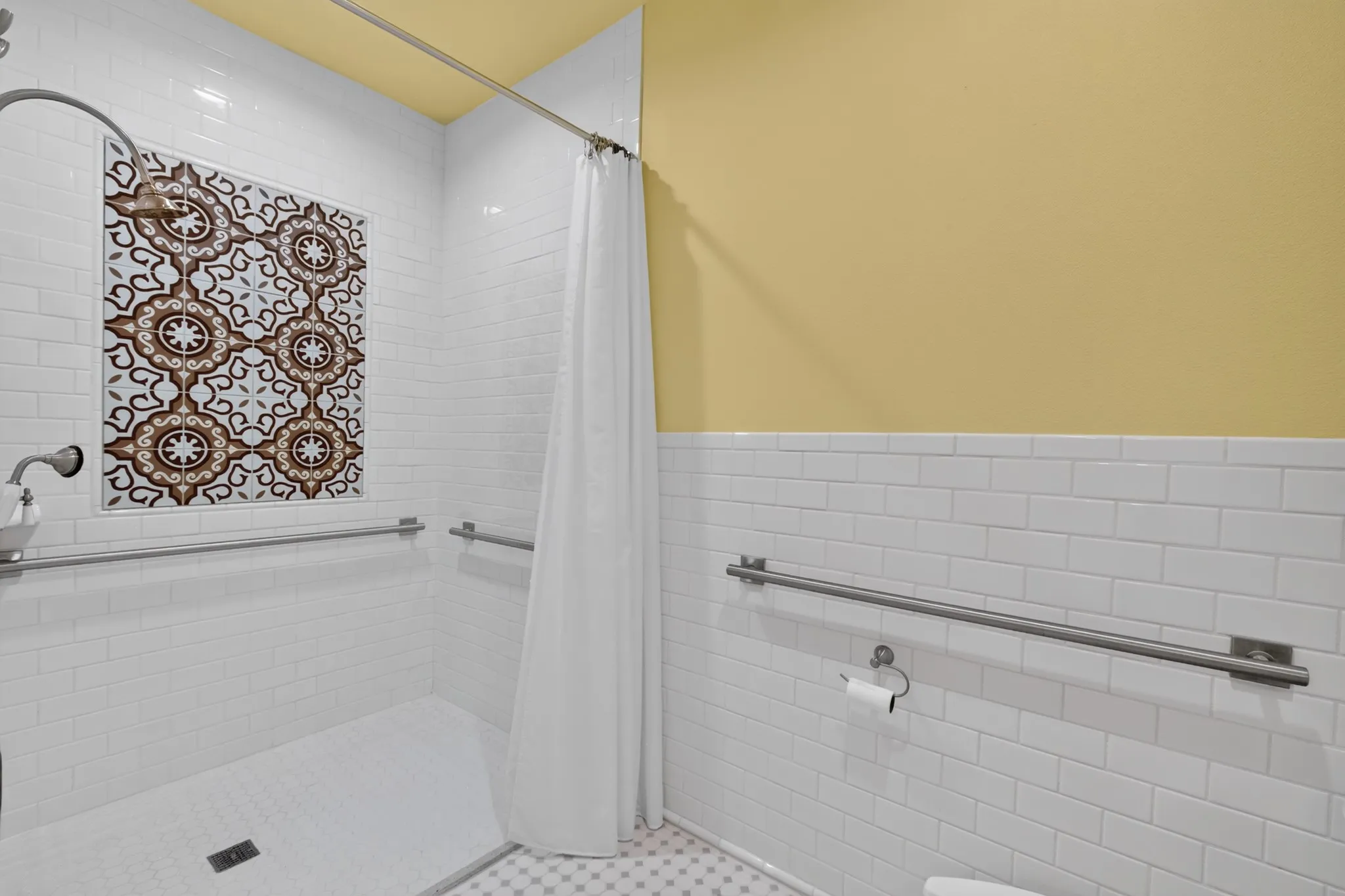 White subway tile walls with accent tile shower surround