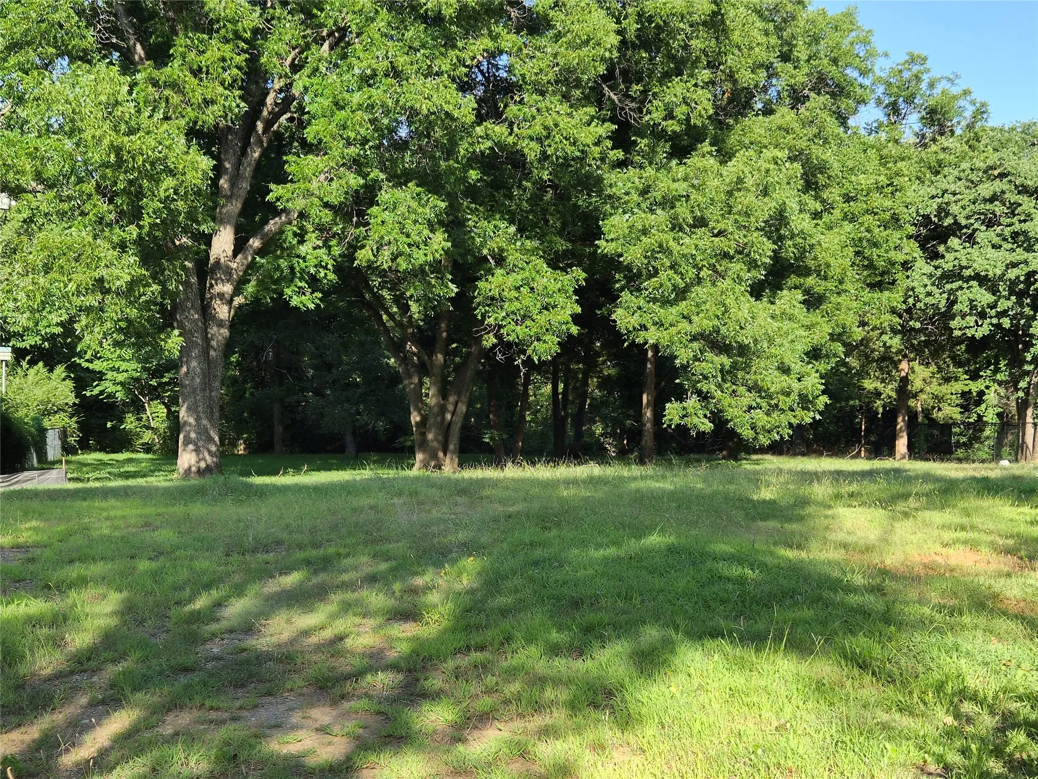 The property extends past the tree line and across the stream.