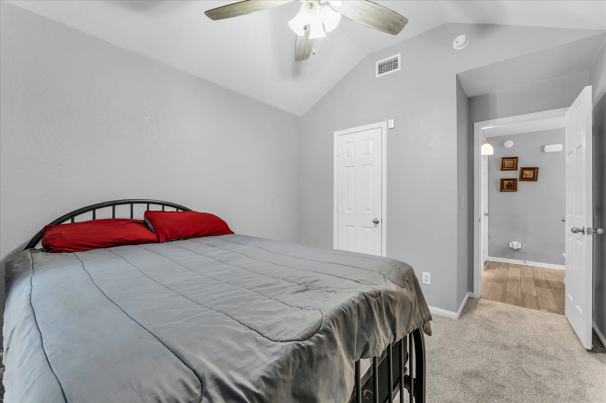 Vaulted ceiling bedroom featuring a ceiling fan, carpet, and light grey walls
