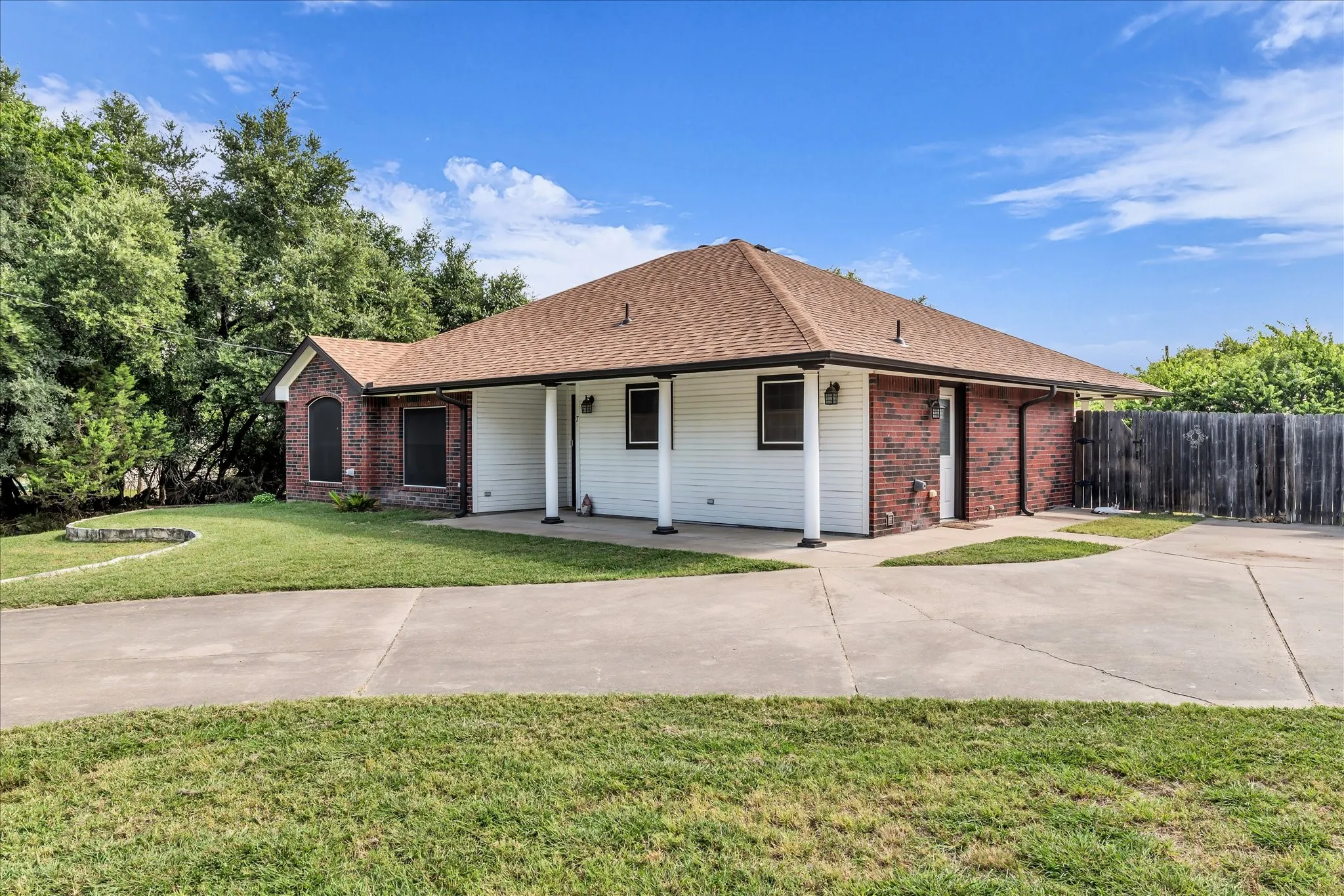 Single-story property featuring a brick and white siding exterior and a concrete driveway