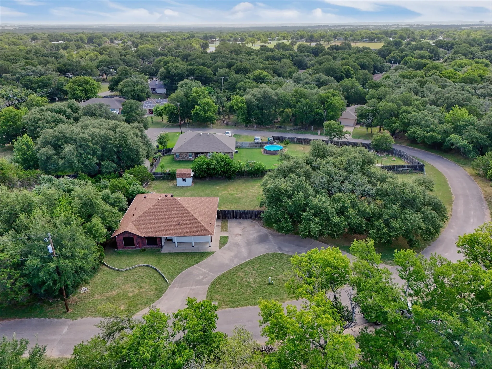 Aerial perspective showcasing a property with a brown shingle roof.