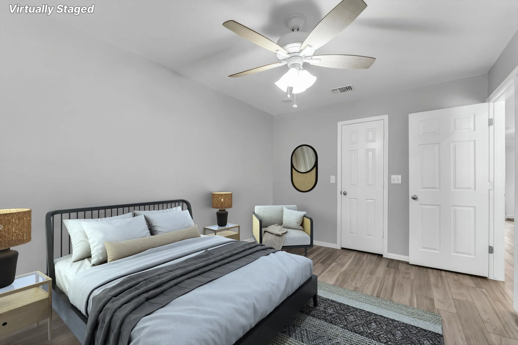 Spacious bedroom featuring wood-finish flooring and a ceiling fan. Virtually staged
