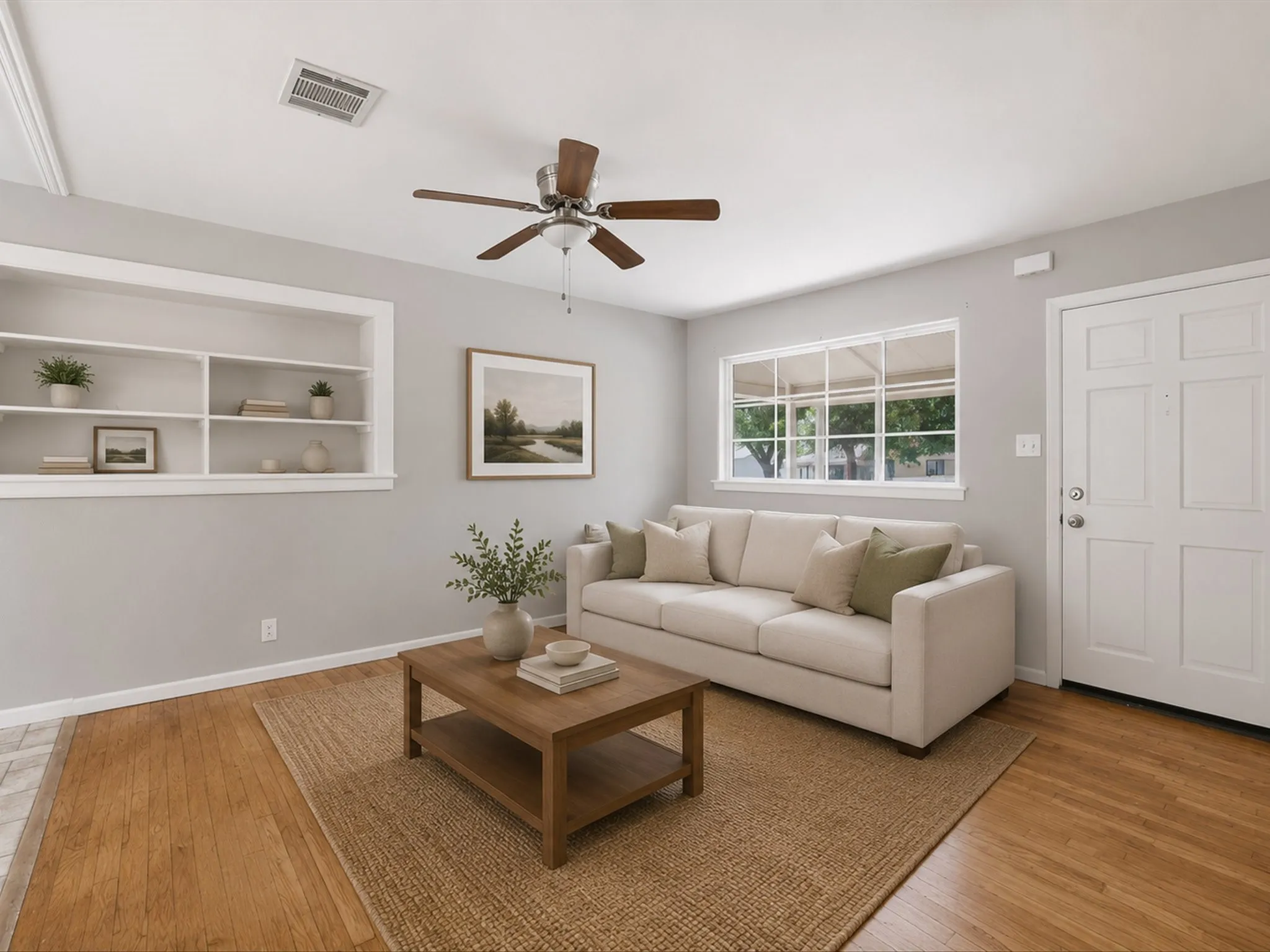 Virtually Staged Living space featuring wood-finish flooring, built-in shelving, white trim, a multi-pane window, and a paneled entry door