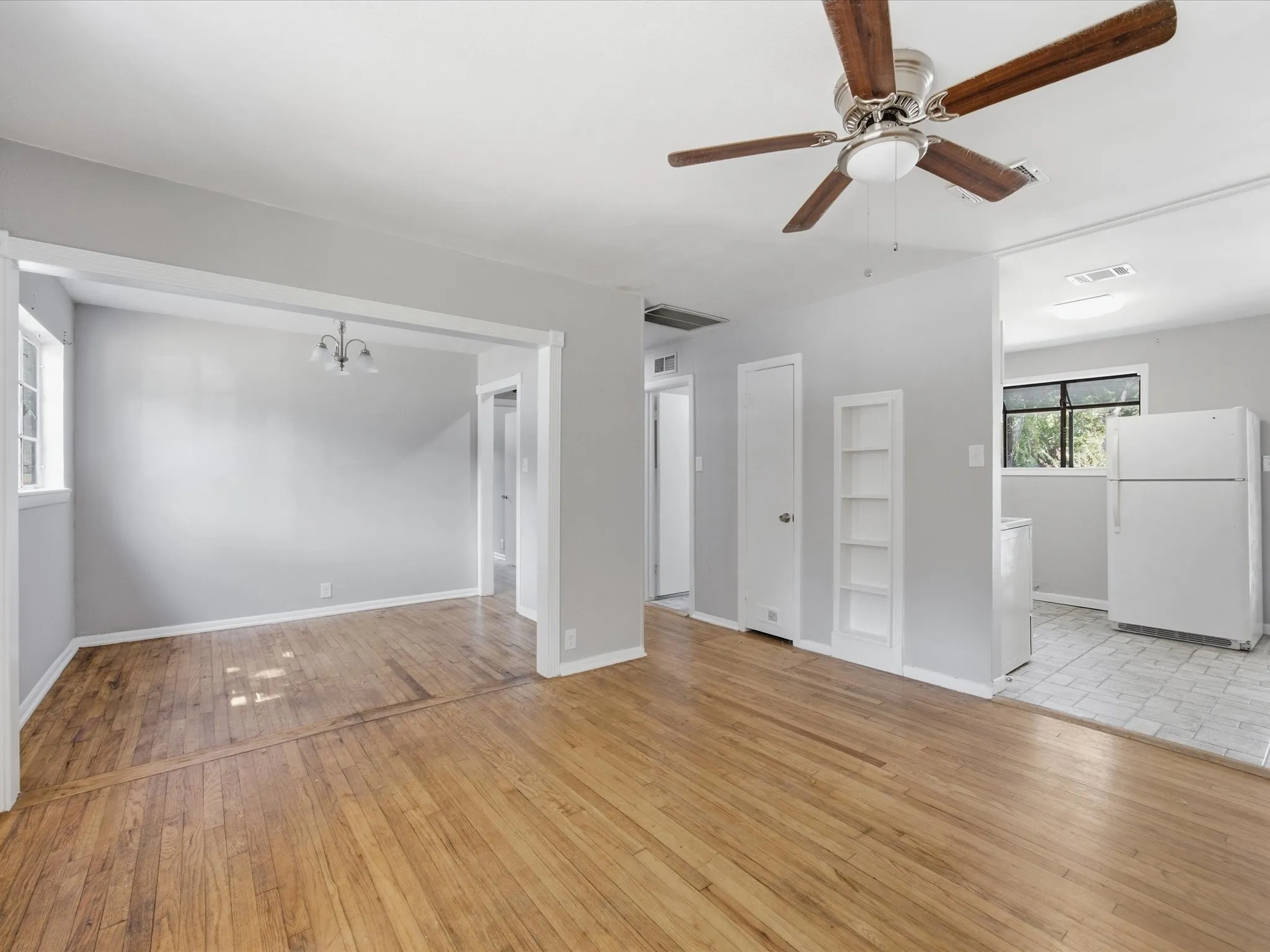 Bright interior living room featuring wood-finish flooring adjacent to Dining & Kitchen