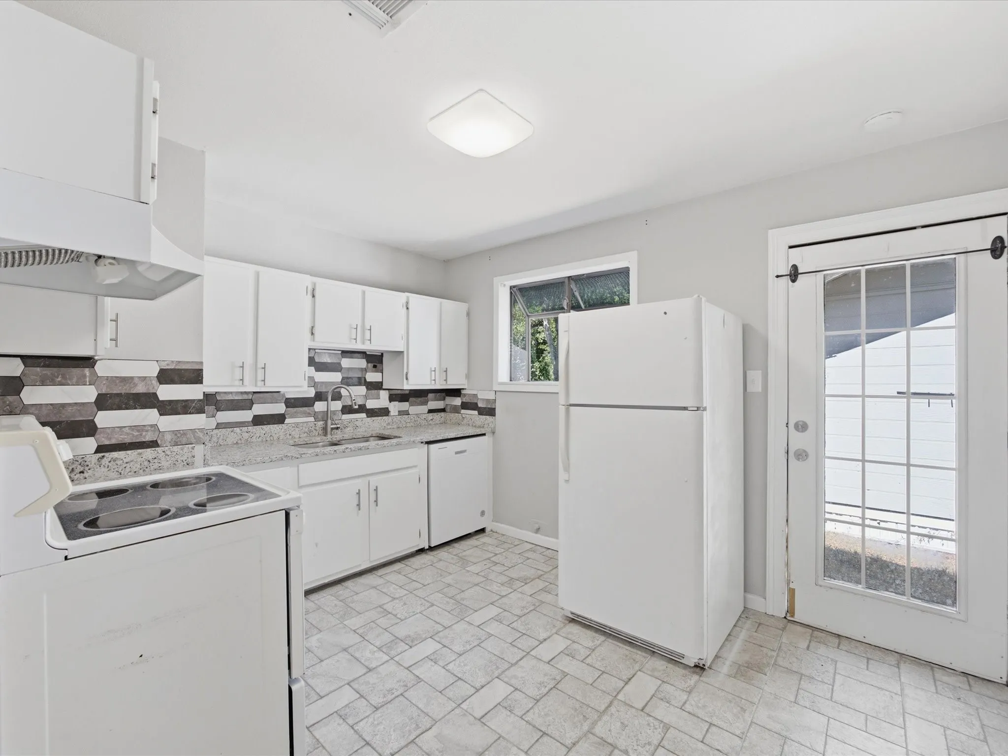 Kitchen featuring white cabinetry, a dual-tone tile backsplash, granite-patterned countertops, and a full suite of appliances including a range, vent hood, and dishwasher
