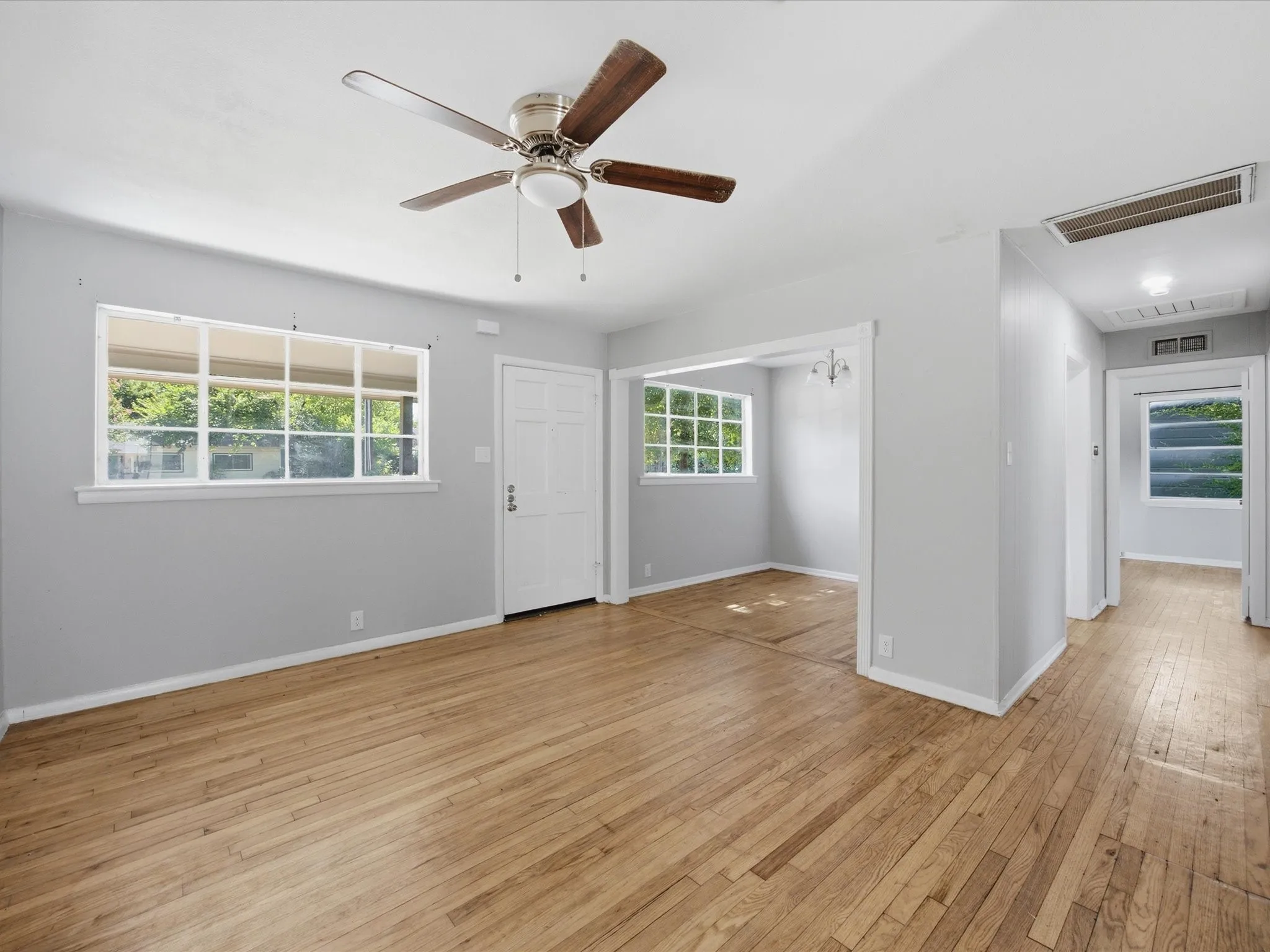 Bright interior living room featuring wood-finish flooring adjacent to Dining & Kitchen