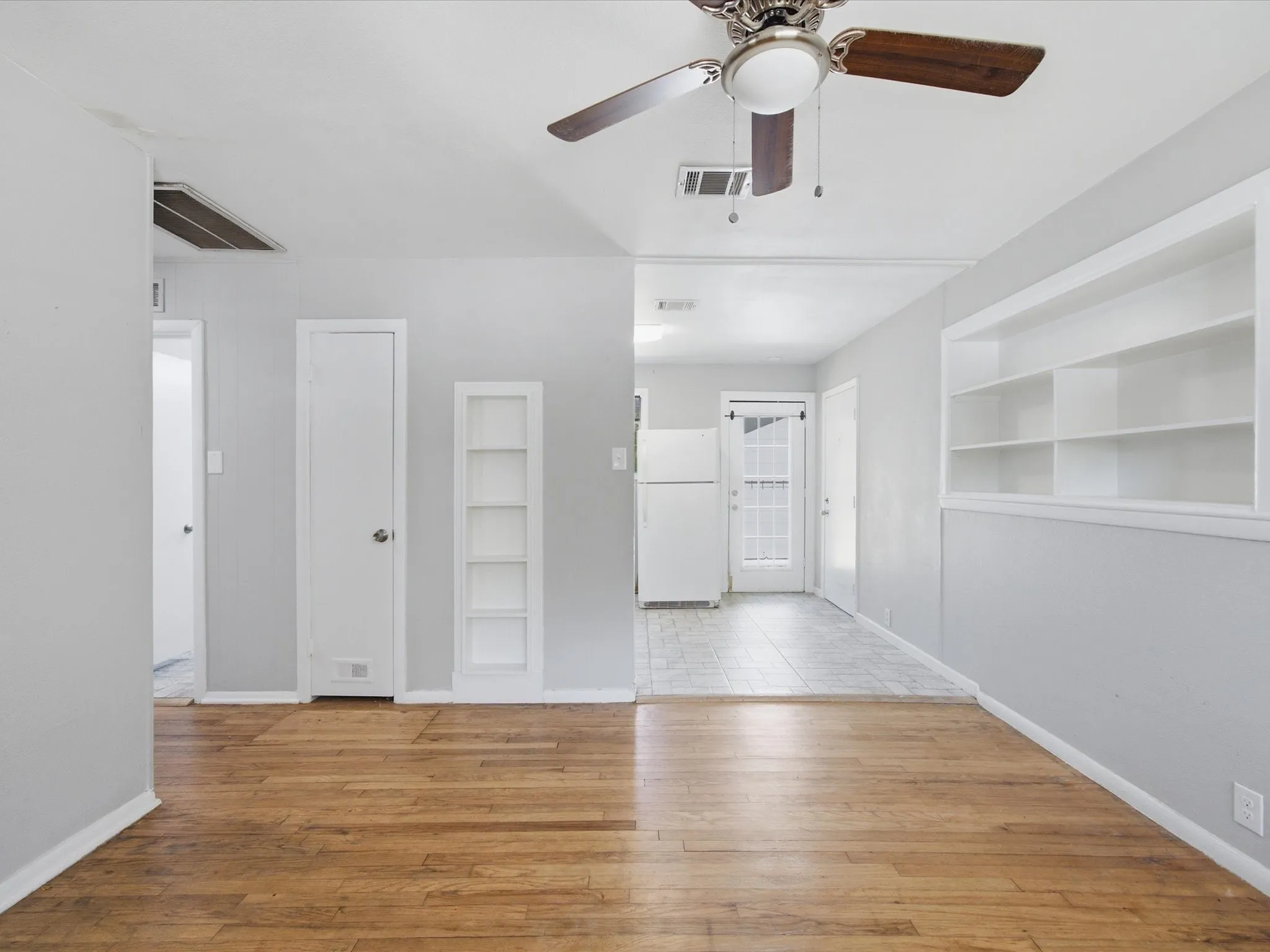 Bright interior living room featuring wood-finish flooring adjacent to Dining & Kitchen