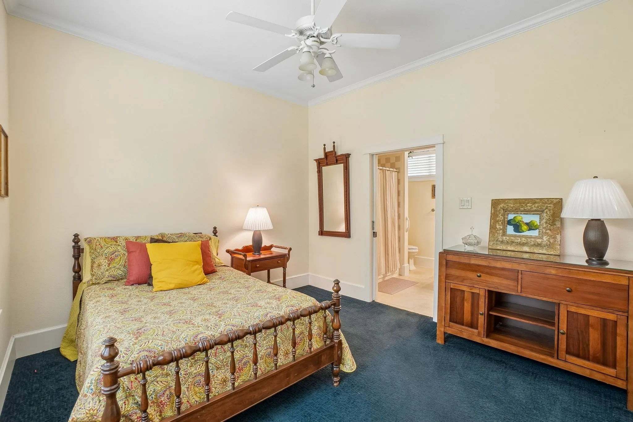Spacious room featuring a ceiling fan, crown molding, and a built-in wood-finish dresser