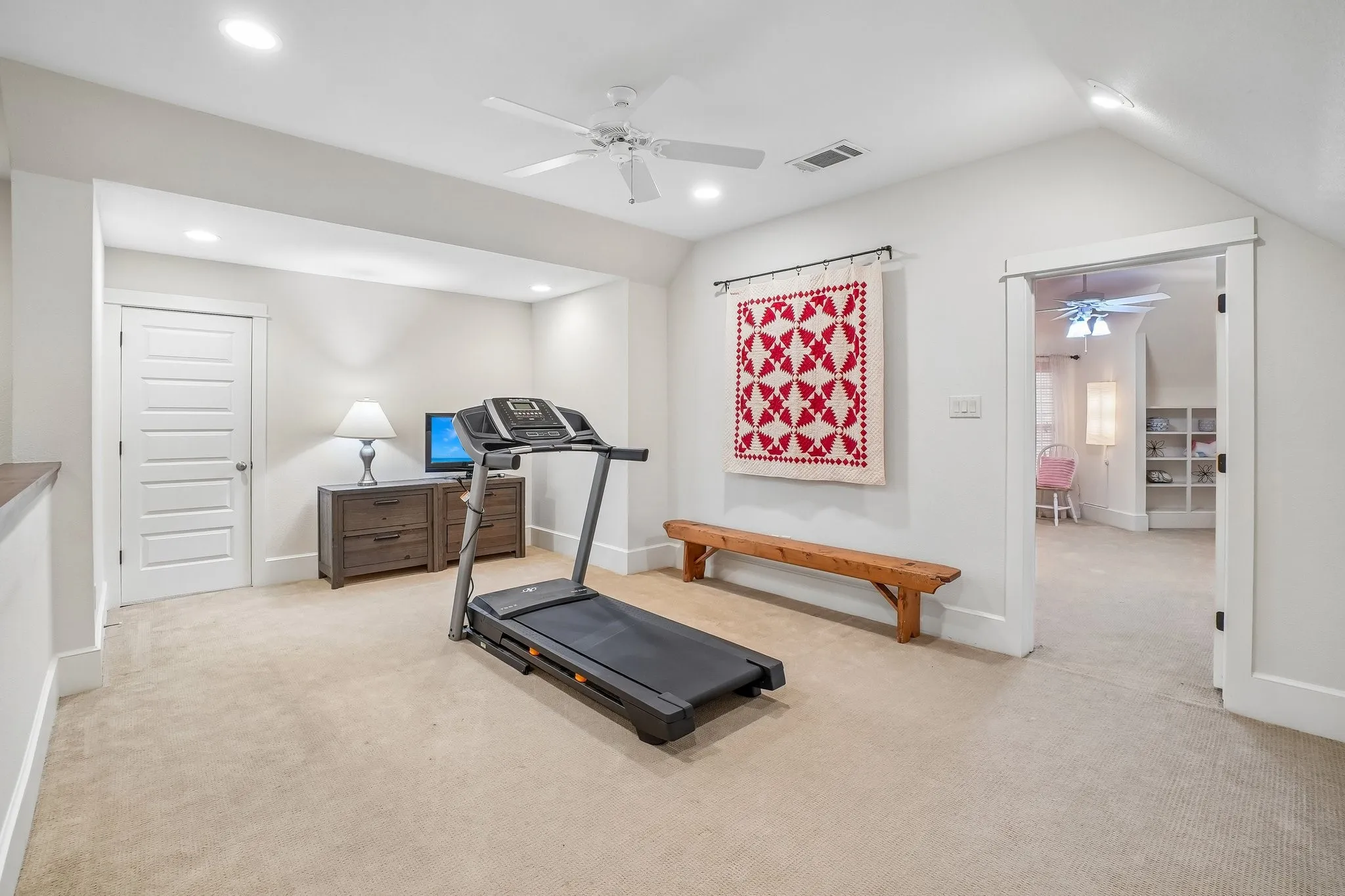 Carpeted room featuring a white ceiling fan, recessed lighting, and a paneled door