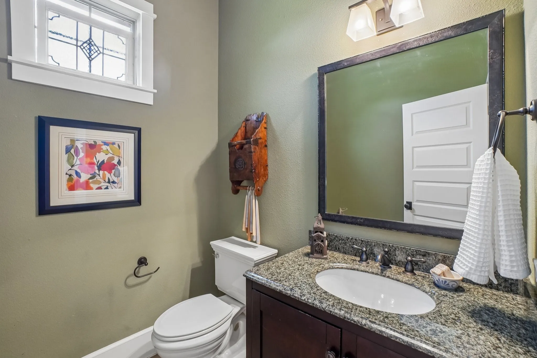 Bathroom featuring a dark wood vanity with a granite countertop and an oval undermount sink