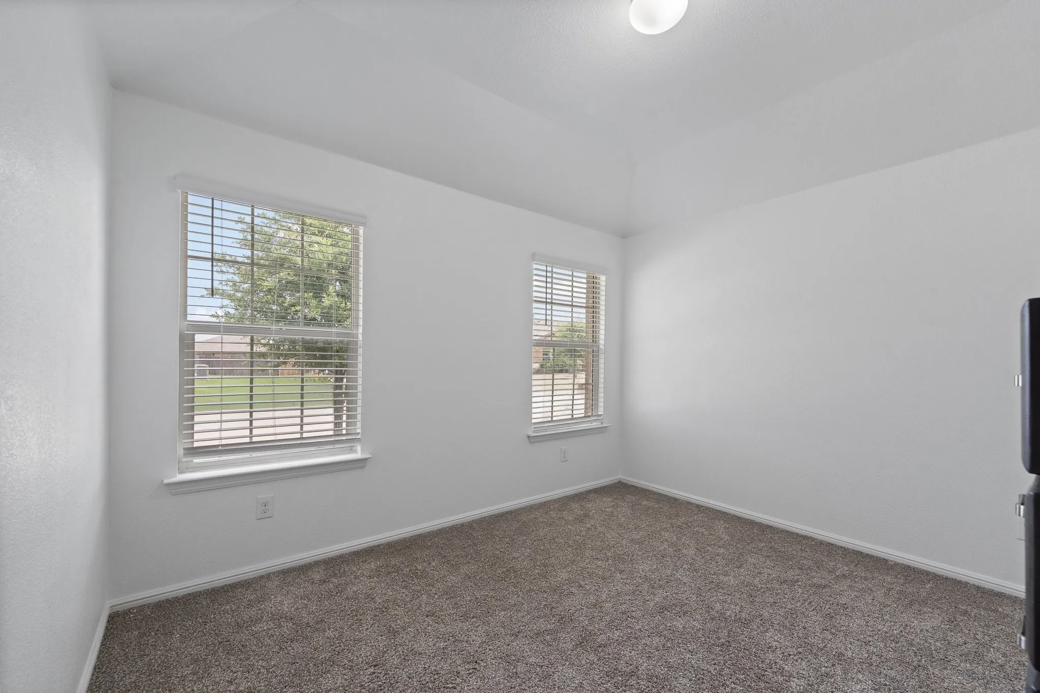 Bright room with neutral wall tones and plush carpeting