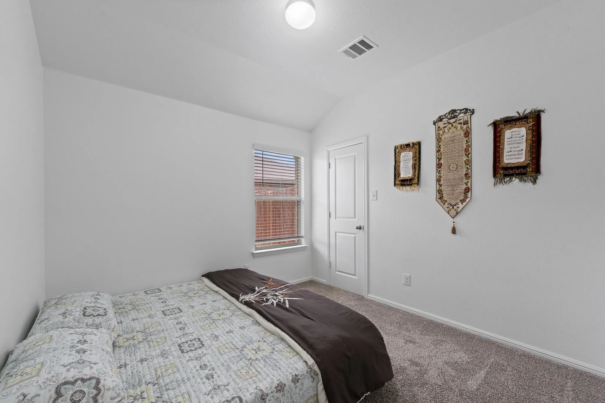 Bedroom featuring neutral wall paint, gray carpeting, a window with horizontal blinds, and a white interior door