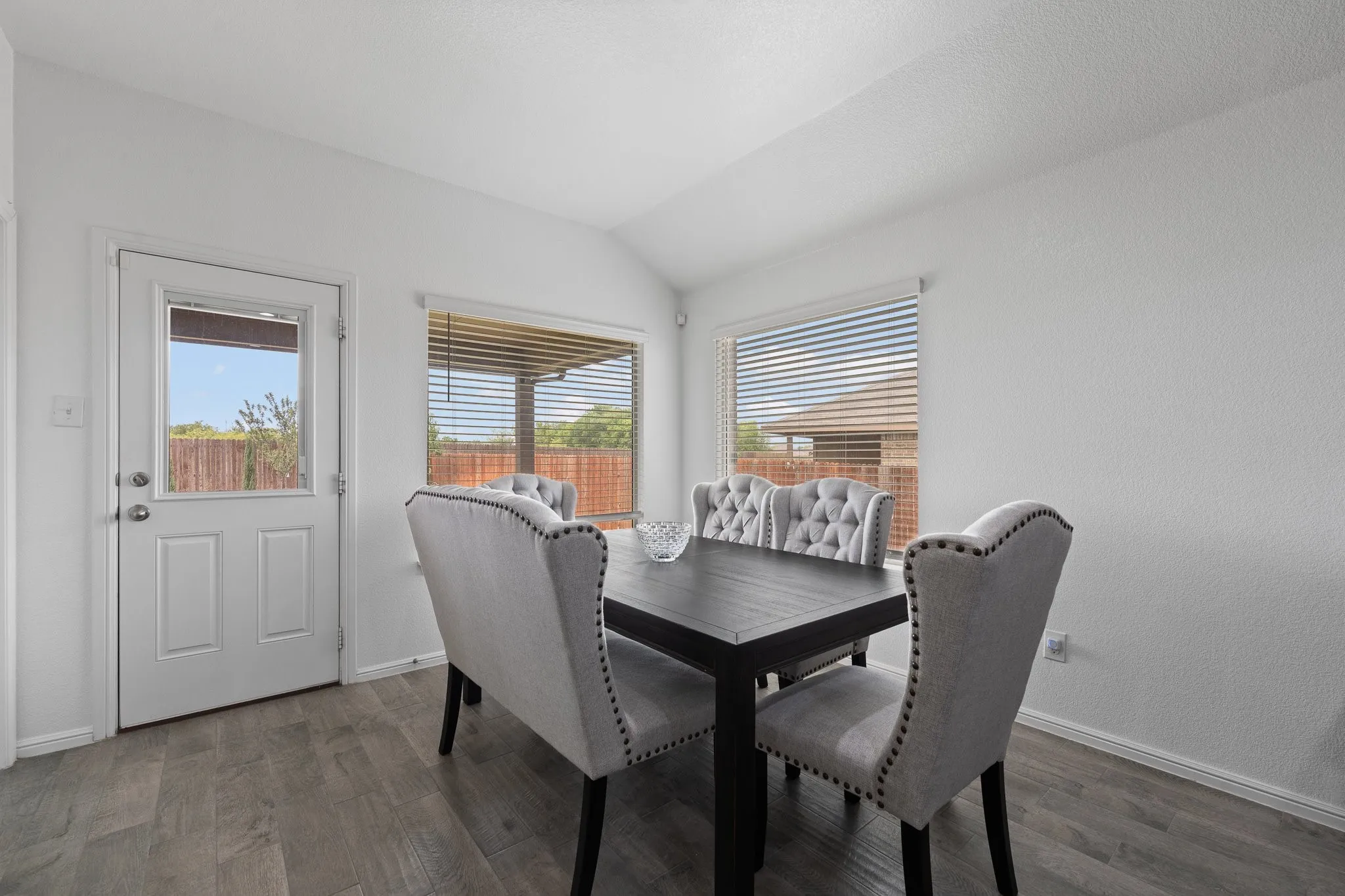 Dining area featuring wood-finish flooring and a white paneled exterior door