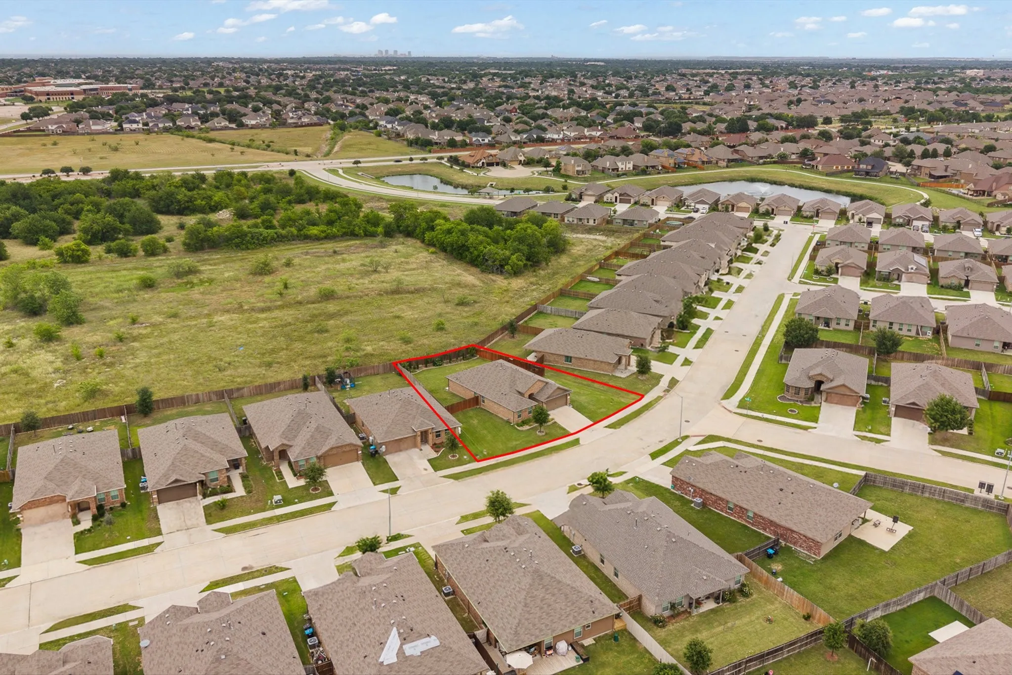 Aerial perspective of a suburban neighborhood featuring single-story homes with brick exteriors and attached garages