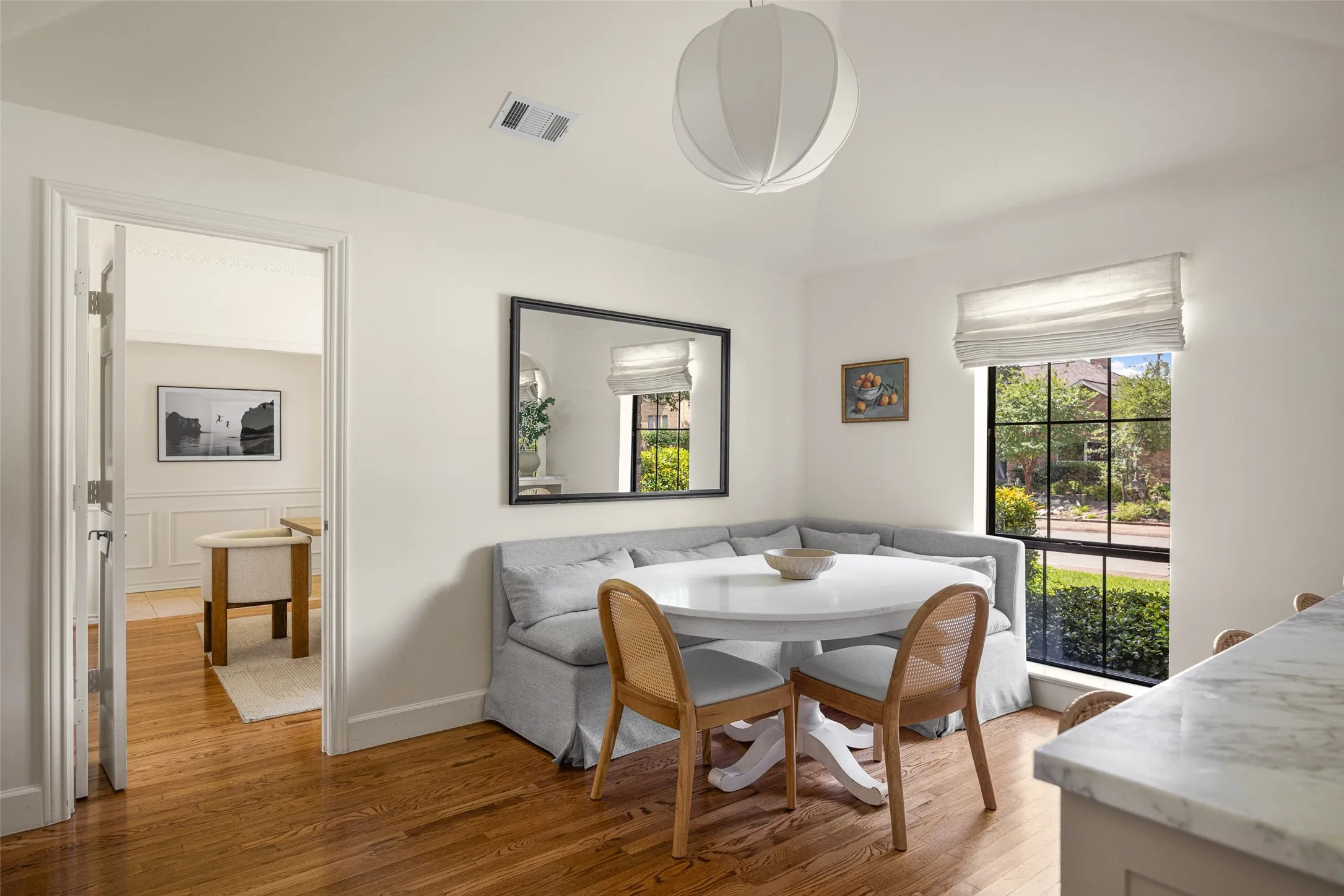 Breakfast nook featuring a built-in banquette, a large window with exterior views, and wood flooring