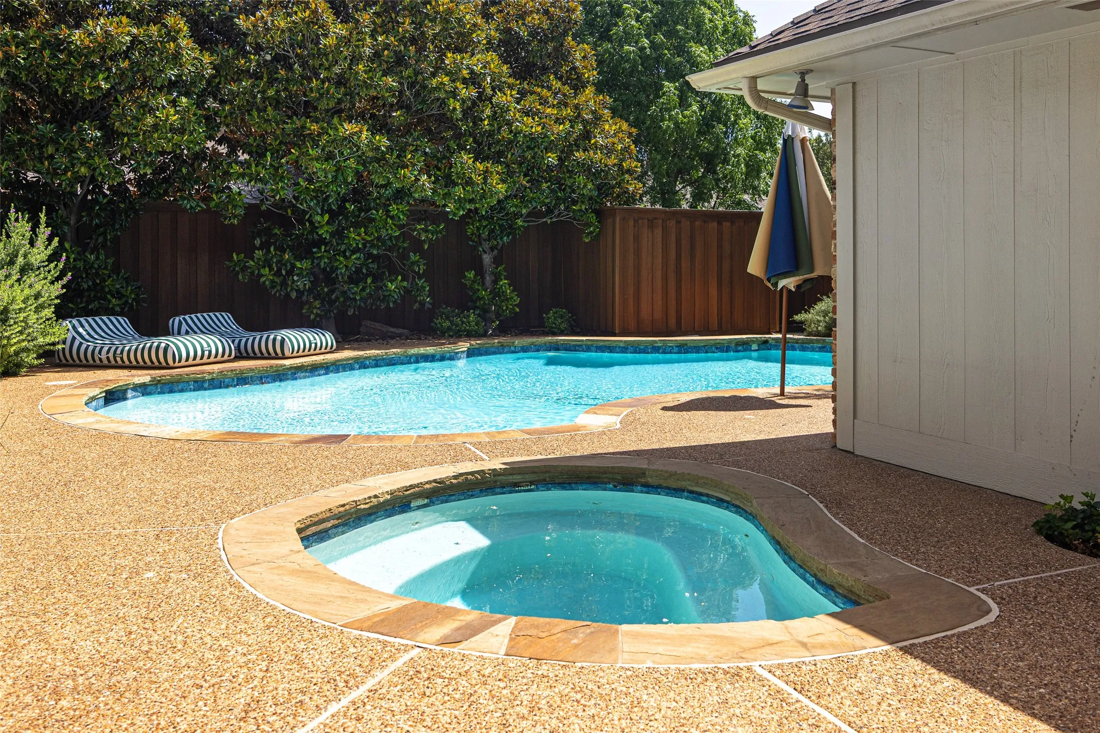 Backyard oasis featuring an in-ground swimming pool and integrated spa
