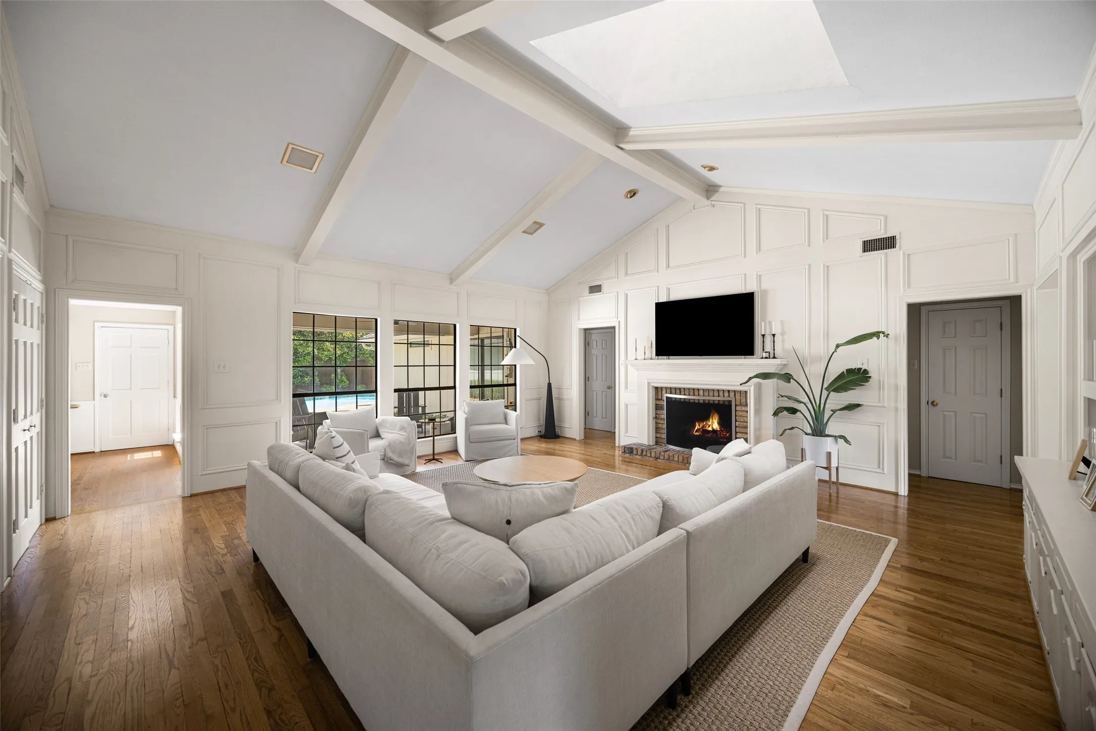 Vaulted ceiling with exposed beams and recessed lighting