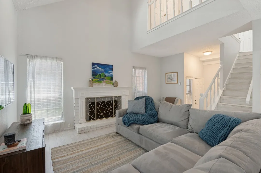 Bright, open living area featuring a two-story layout with abundant natural light from multiple windows and skylights