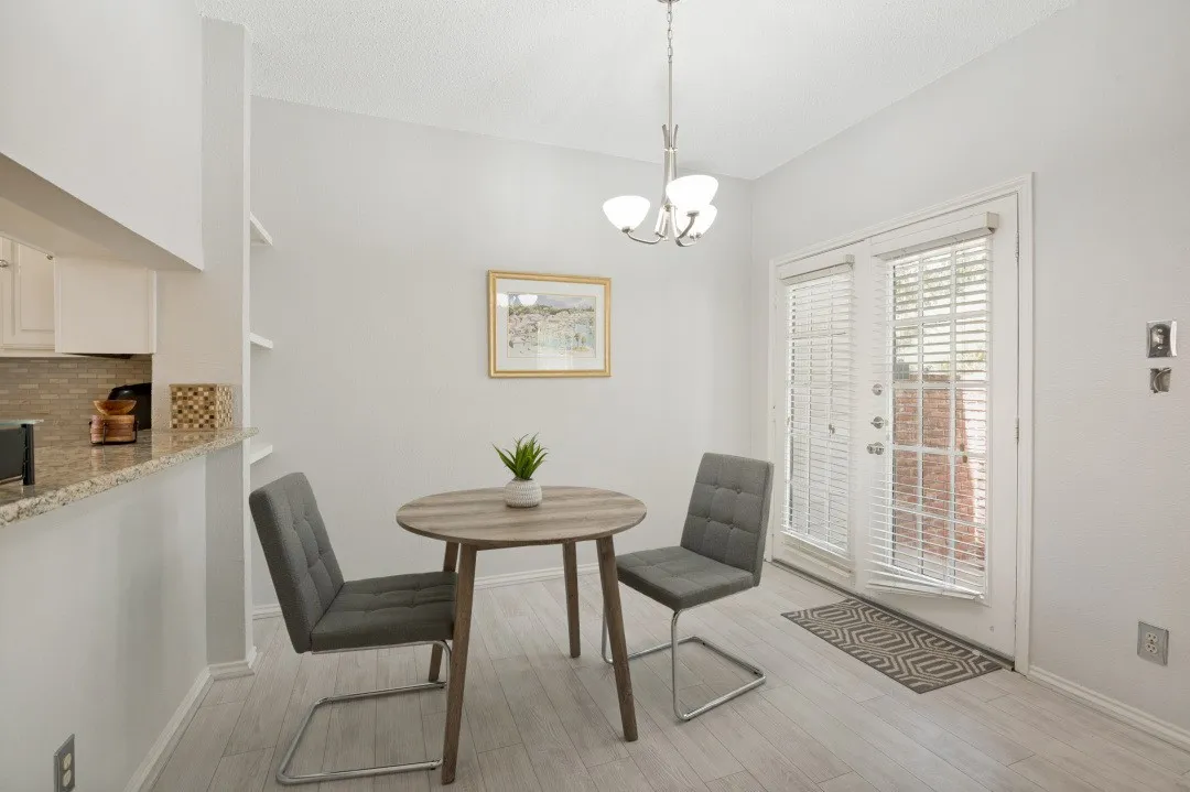 Vaulted ceiling, wood-finish flooring, built-in shelving, breakfast bar with granite countertop, and double glass doors