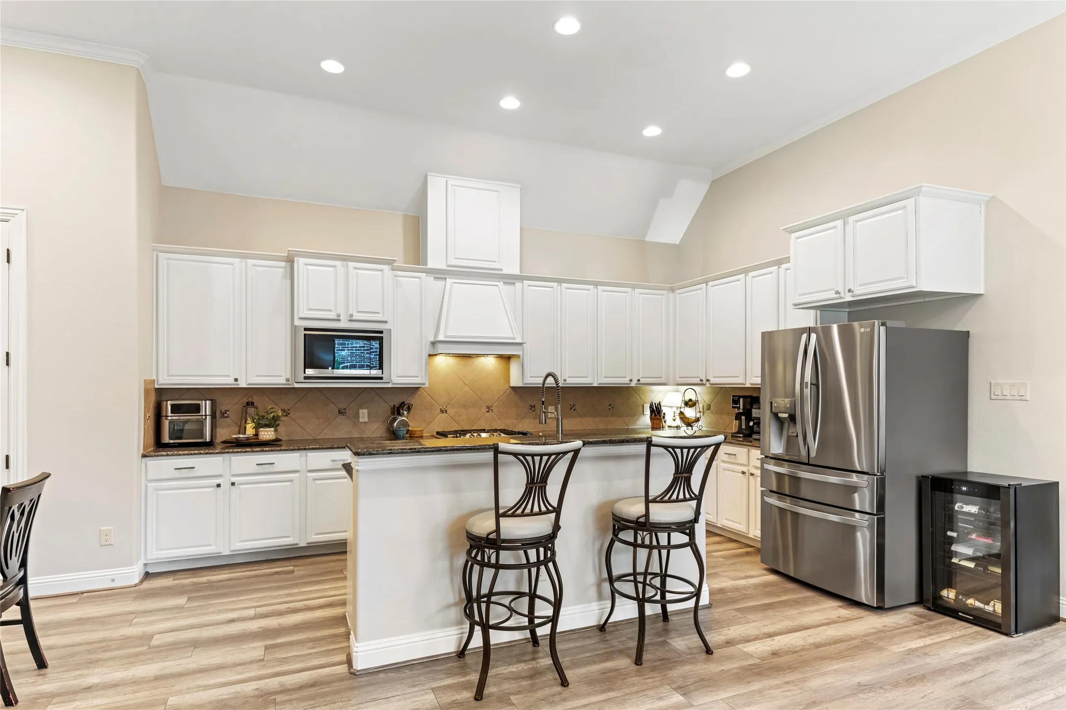 Freshly painted cabinets, granite counters, gas cooktop, vented hood, LG oven & microwave, Kohler sink & faucet,