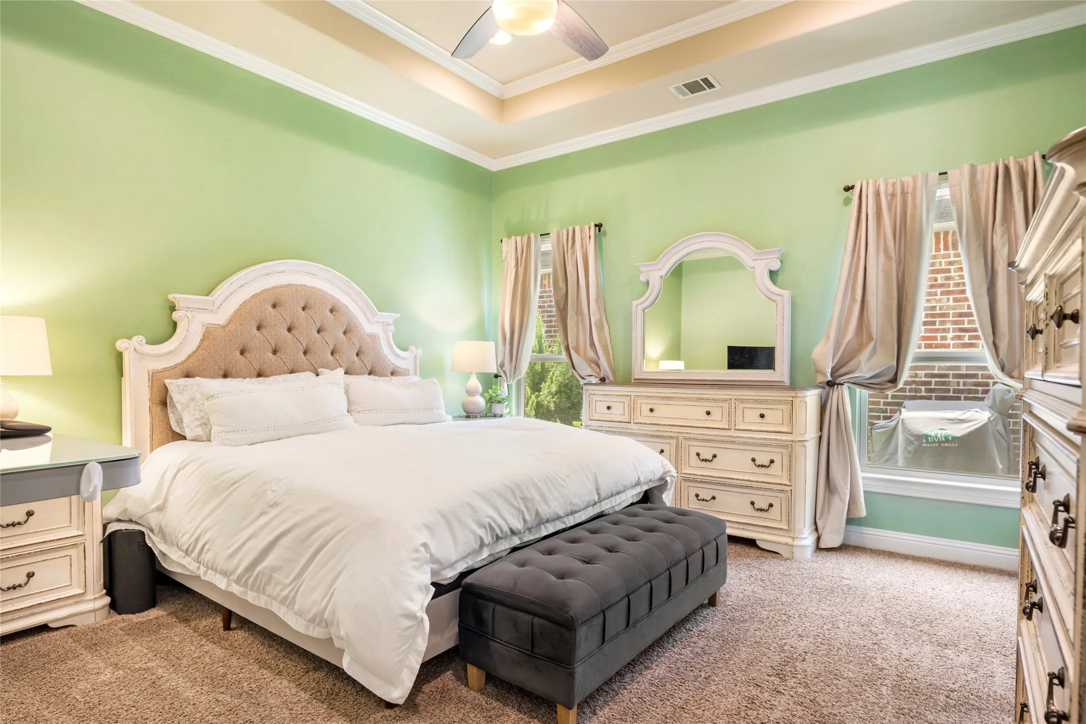 Spacious primary bedroom with an upgraded tray ceiling and additional can lights. The paint is a more subtle green than shown in this pic due to the photo editing.