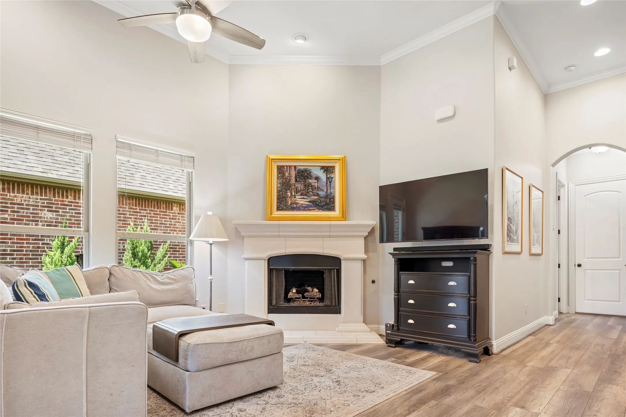 Living room boasts a 12 foot ceiling, gas fireplace, picture windows, and luxury vinyl plank flooring.