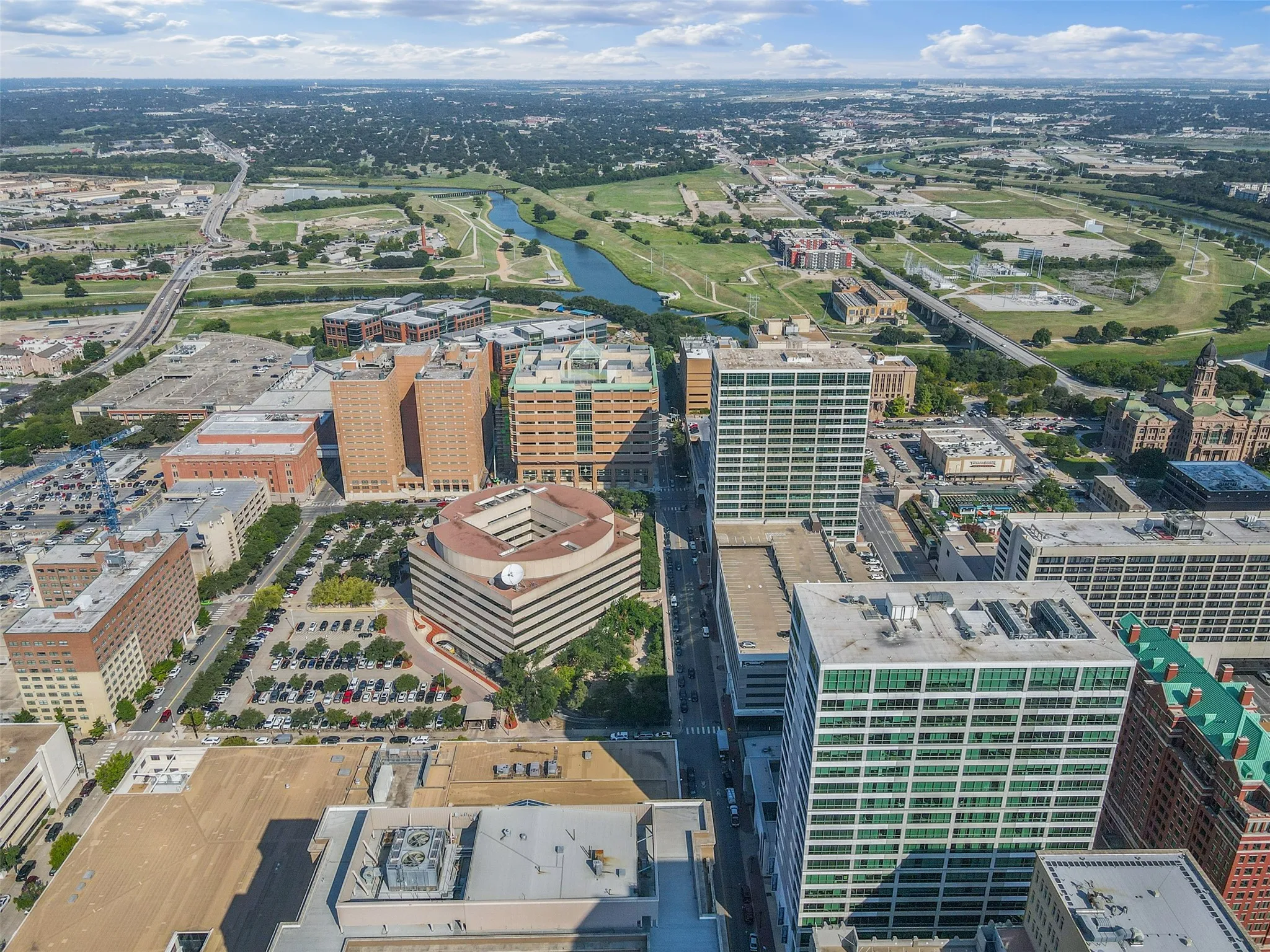 Urban skyline featuring a collection of high-rise buildings, vehicular thoroughfares, and a distant river