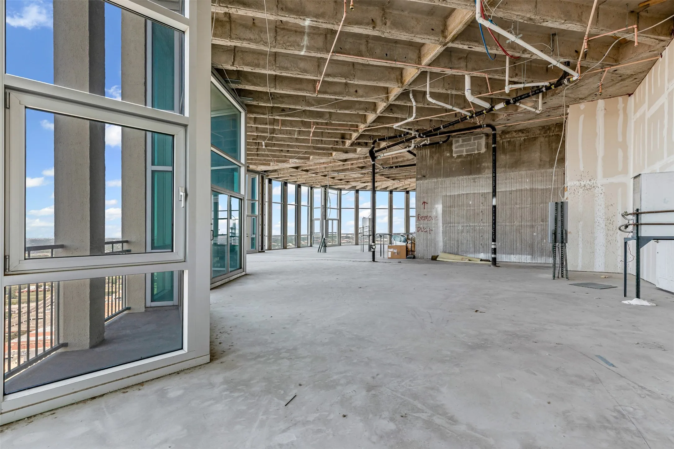 Expansive unfinished interior with concrete flooring and exposed ceiling infrastructure