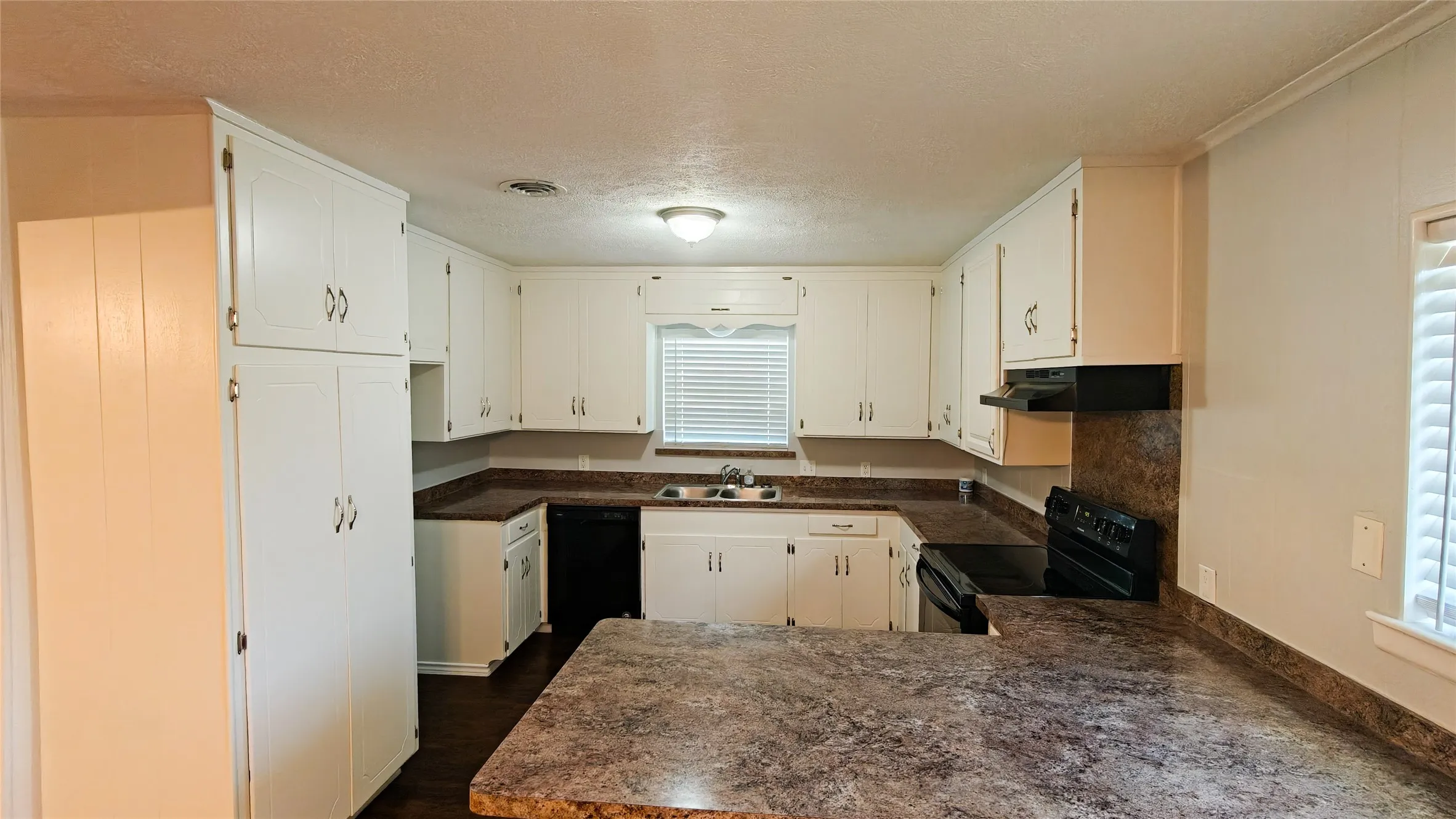 Kitchen featuring white cabinetry, dark wood-finish flooring, and a peninsula countertop