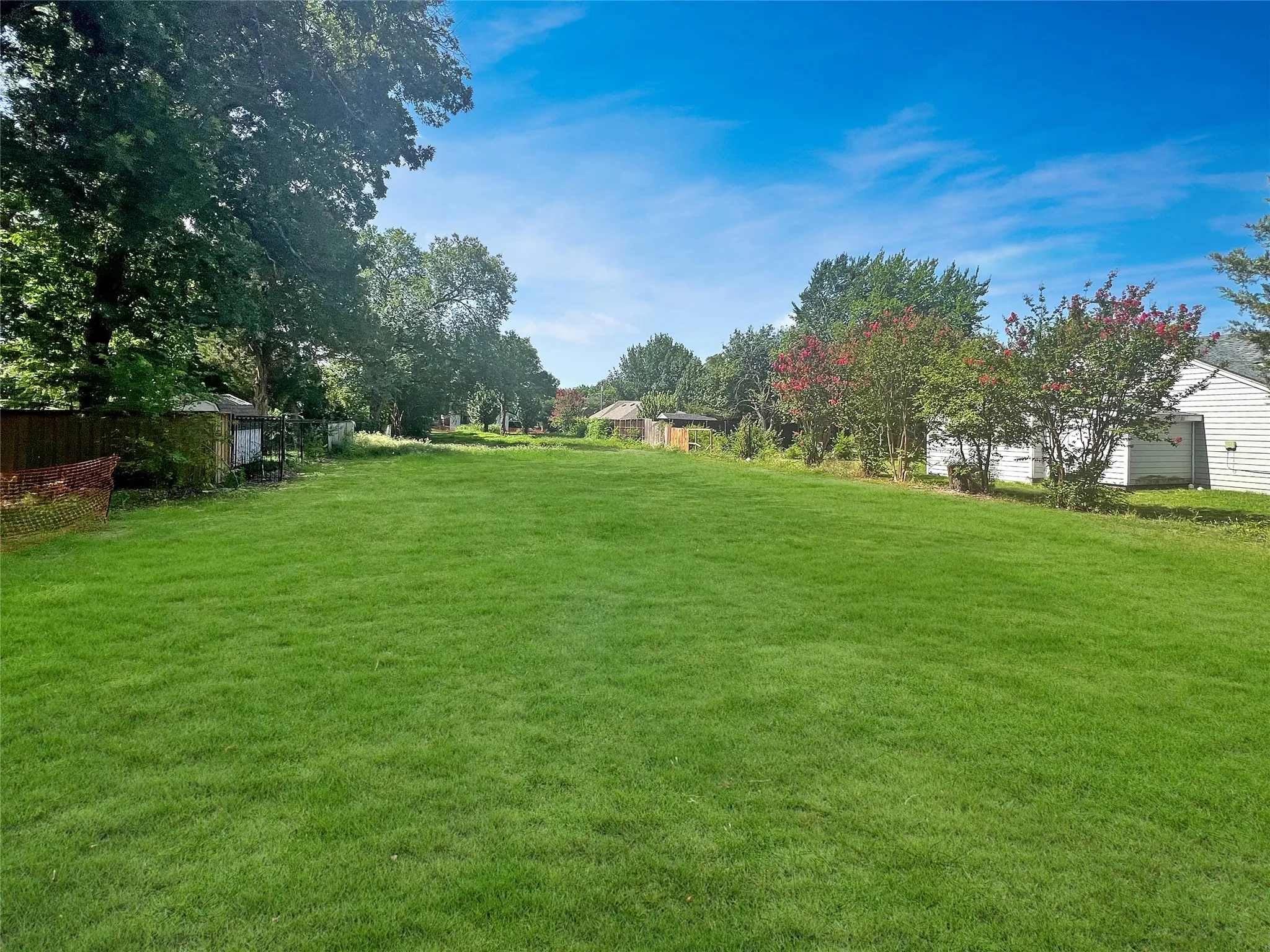 Expansive green lawn with mature trees and shrubbery