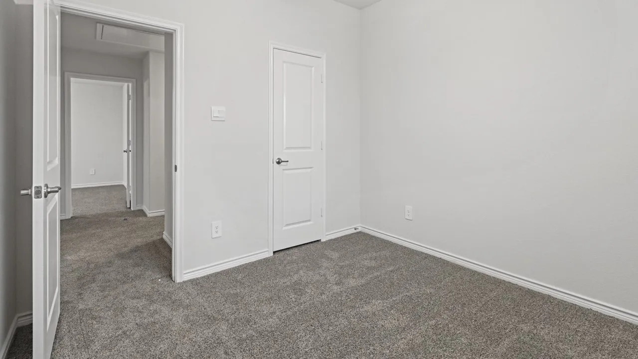 Neutral toned wall paint with a contrasting white trim and textured gray carpet