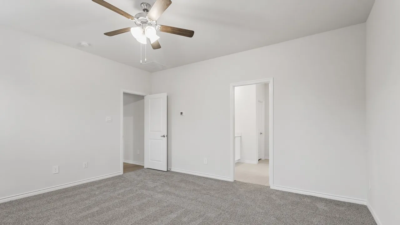 Spacious interior room featuring light gray carpeting and white walls