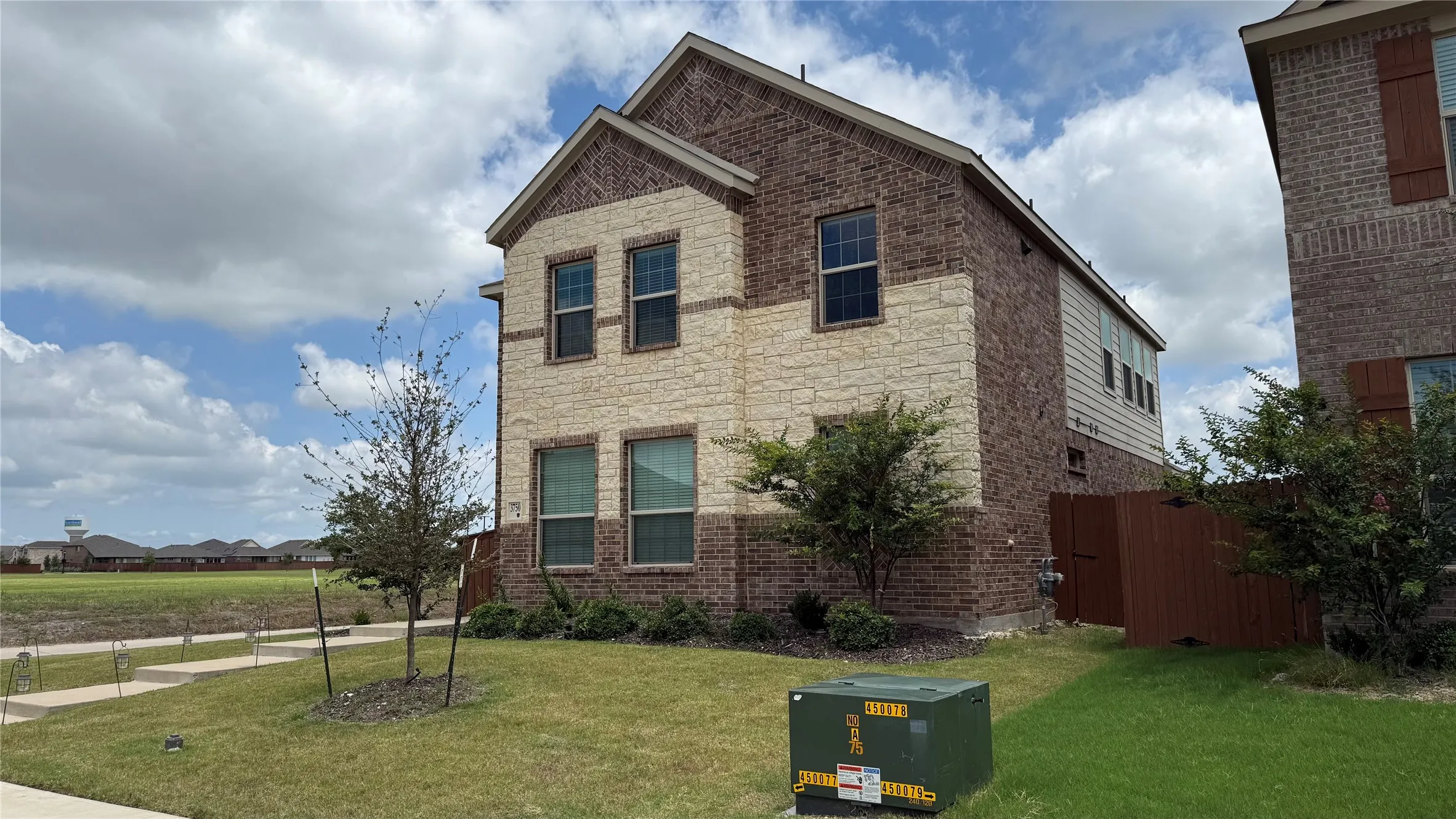 Two-story exterior featuring a brick and stone facade
