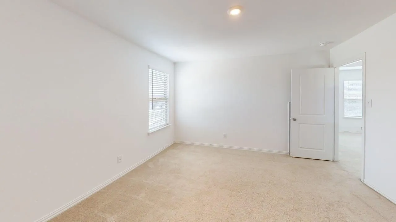 Carpeted room featuring a single window with horizontal blinds, white walls, and a recessed ceiling light