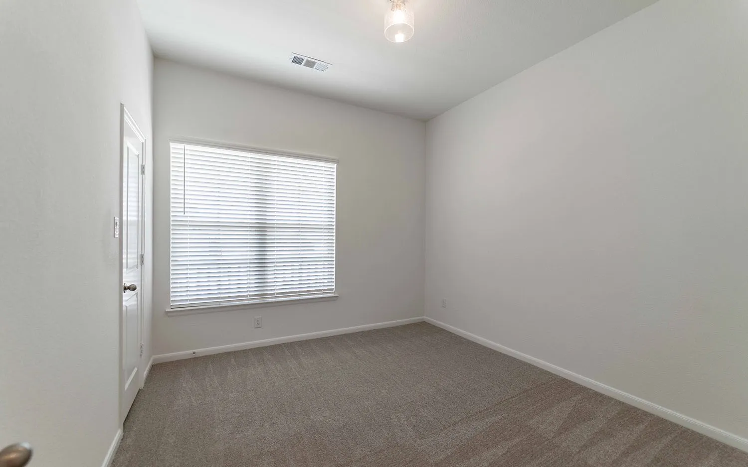 Room with neutral carpeting and white walls