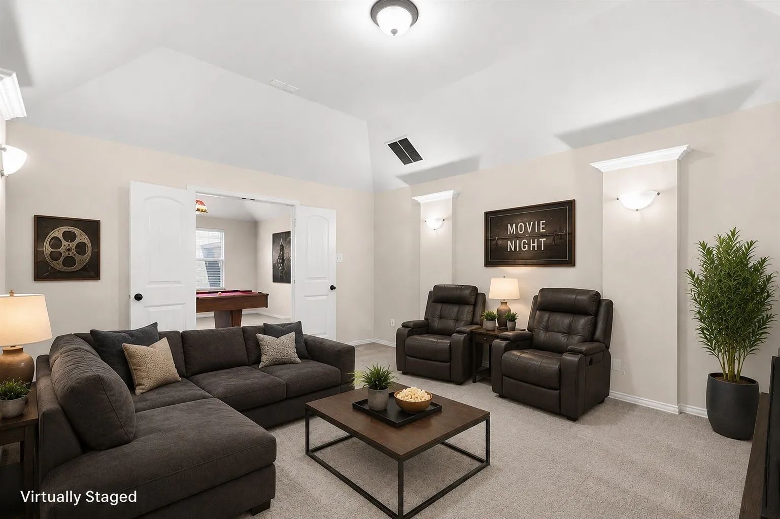 Vaulted ceiling, neutral wall tones, carpet flooring, wall sconces, and double arch-top doors
