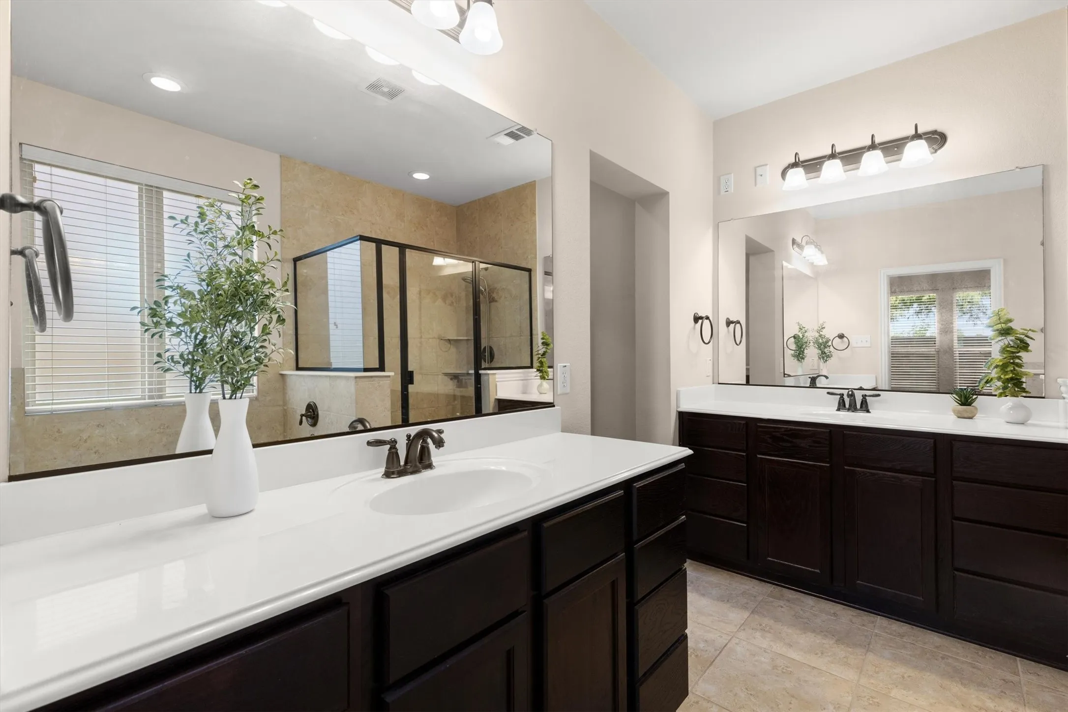 Bathroom featuring a dual vanity with dark wood cabinetry and white countertops