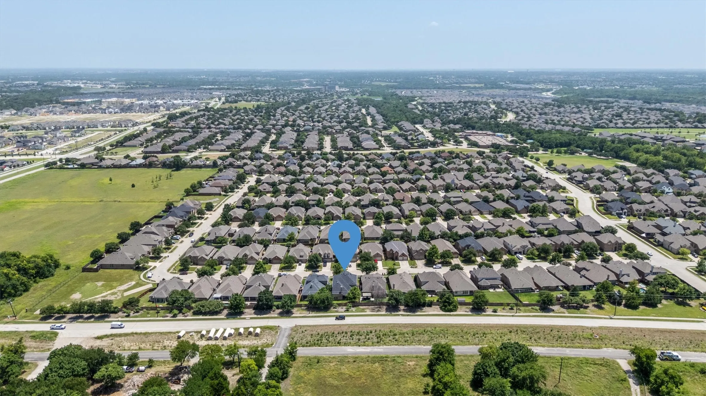Aerial perspective of an established residential community featuring a variety of single-family homes with consistent rooflines and landscaping