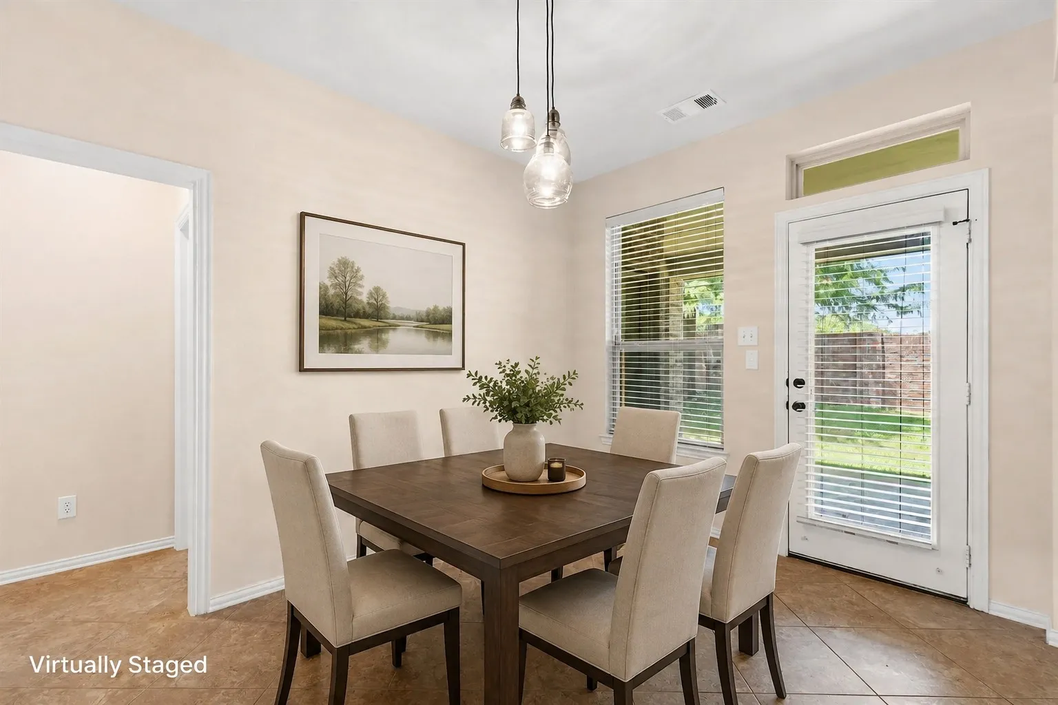 Dining area with tile flooring, a large window, and a glass-paneled door