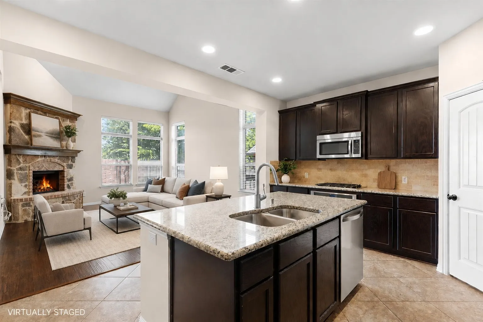 Kitchen island with an undermount dual-basin sink, granite countertops, and stainless steel appliances