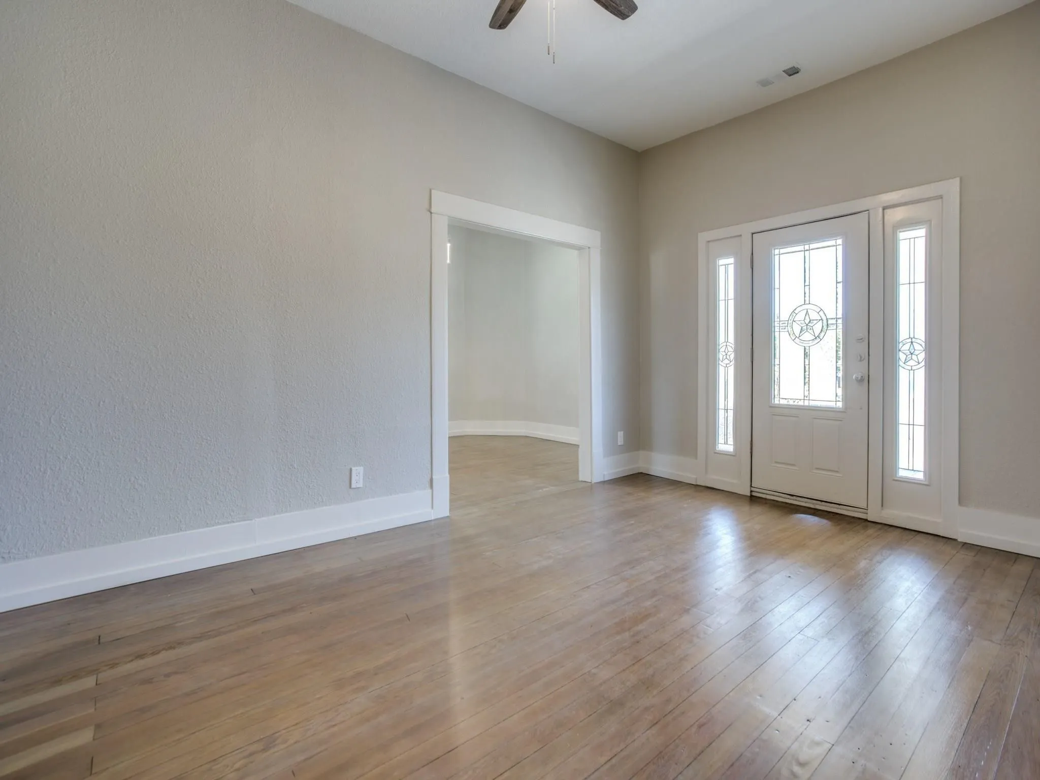 Entryway featuring a white door with star-patterned leaded glass, flanked by matching sidelights