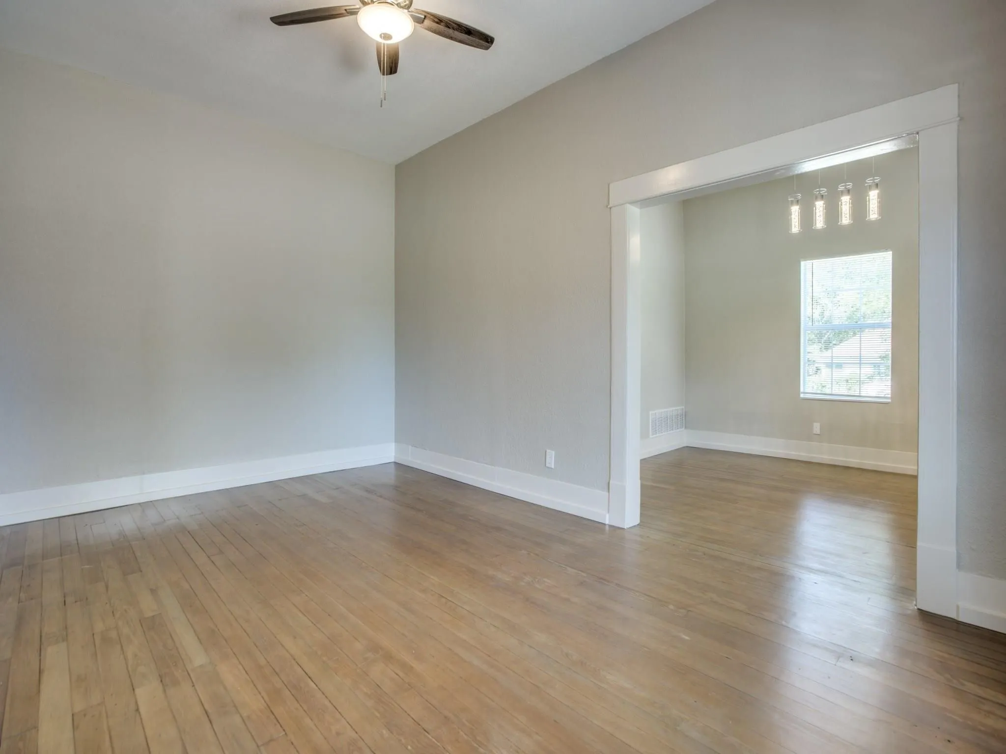 Wood-finish flooring throughout, complemented by a ceiling fan with integrated lighting