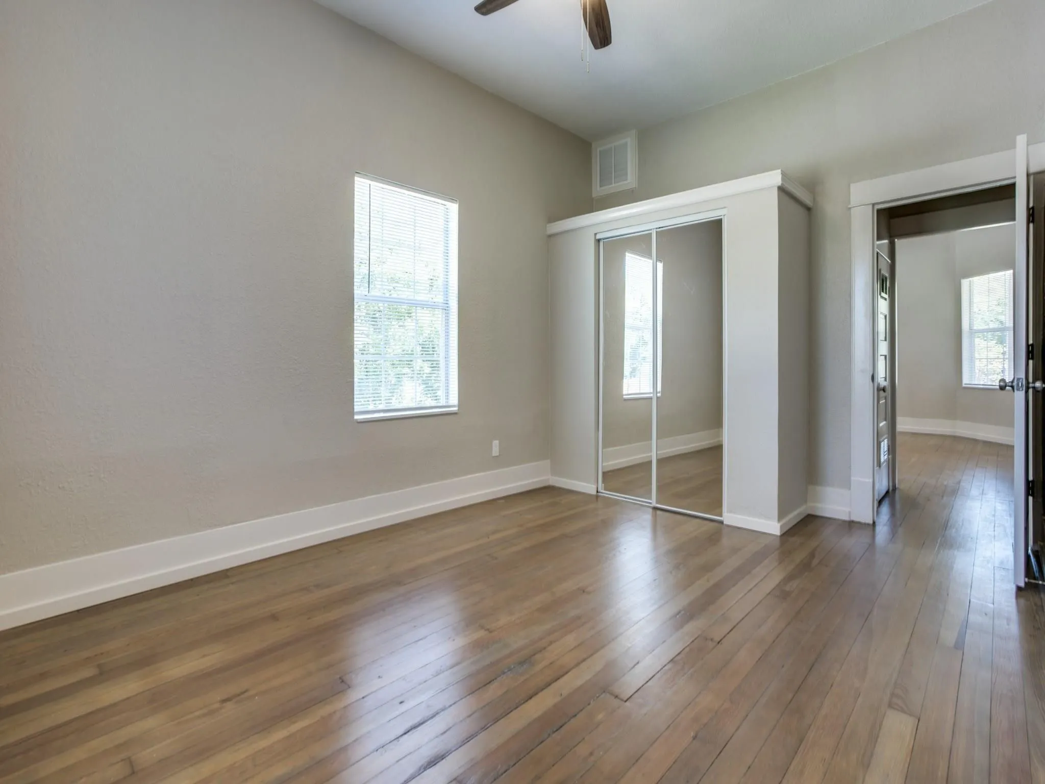 Interior room featuring wood-finish flooring, light neutral wall paint, and white trim