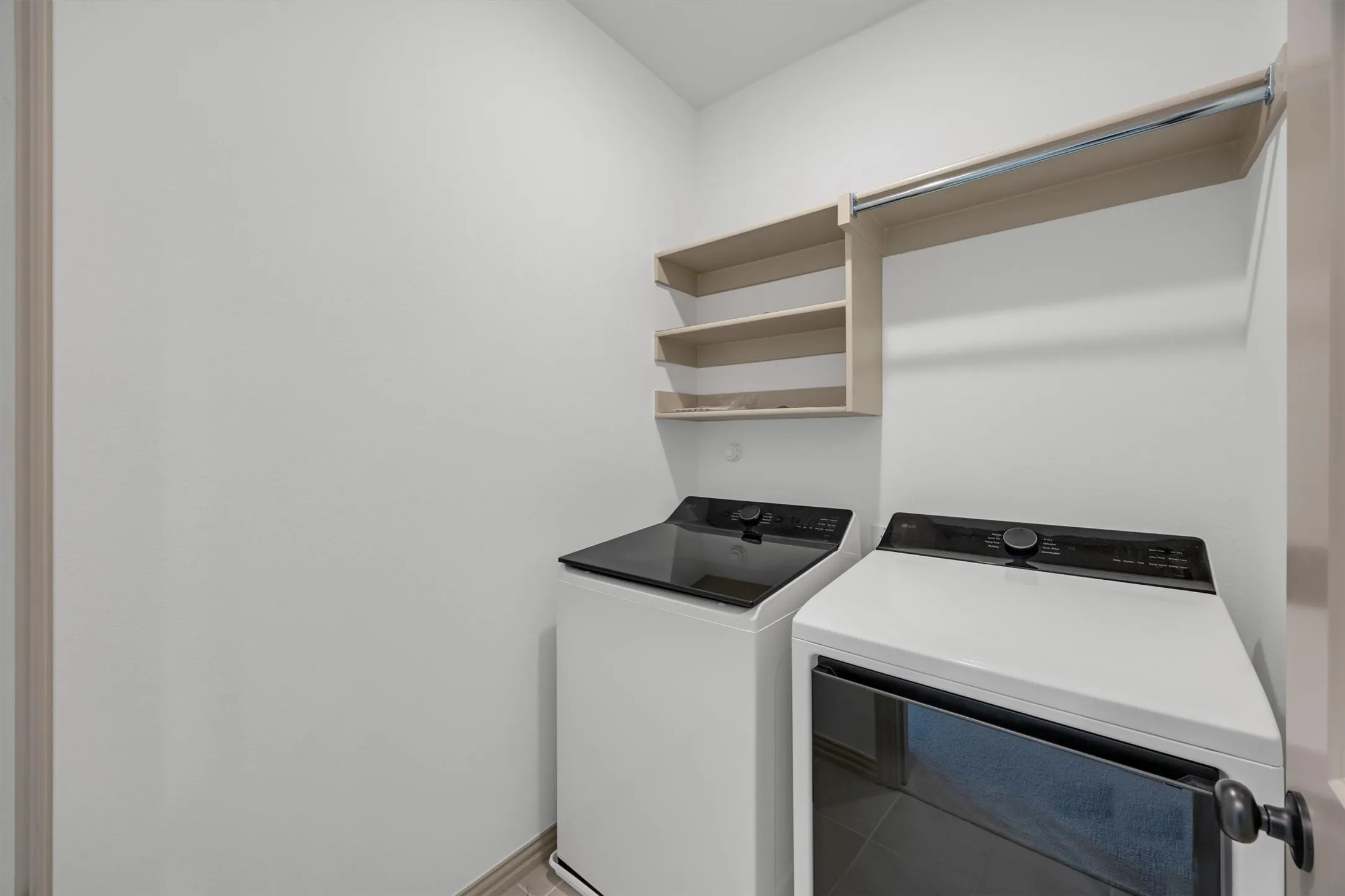 Upstairs laundry room with wood-finish shelving, a hanging rod