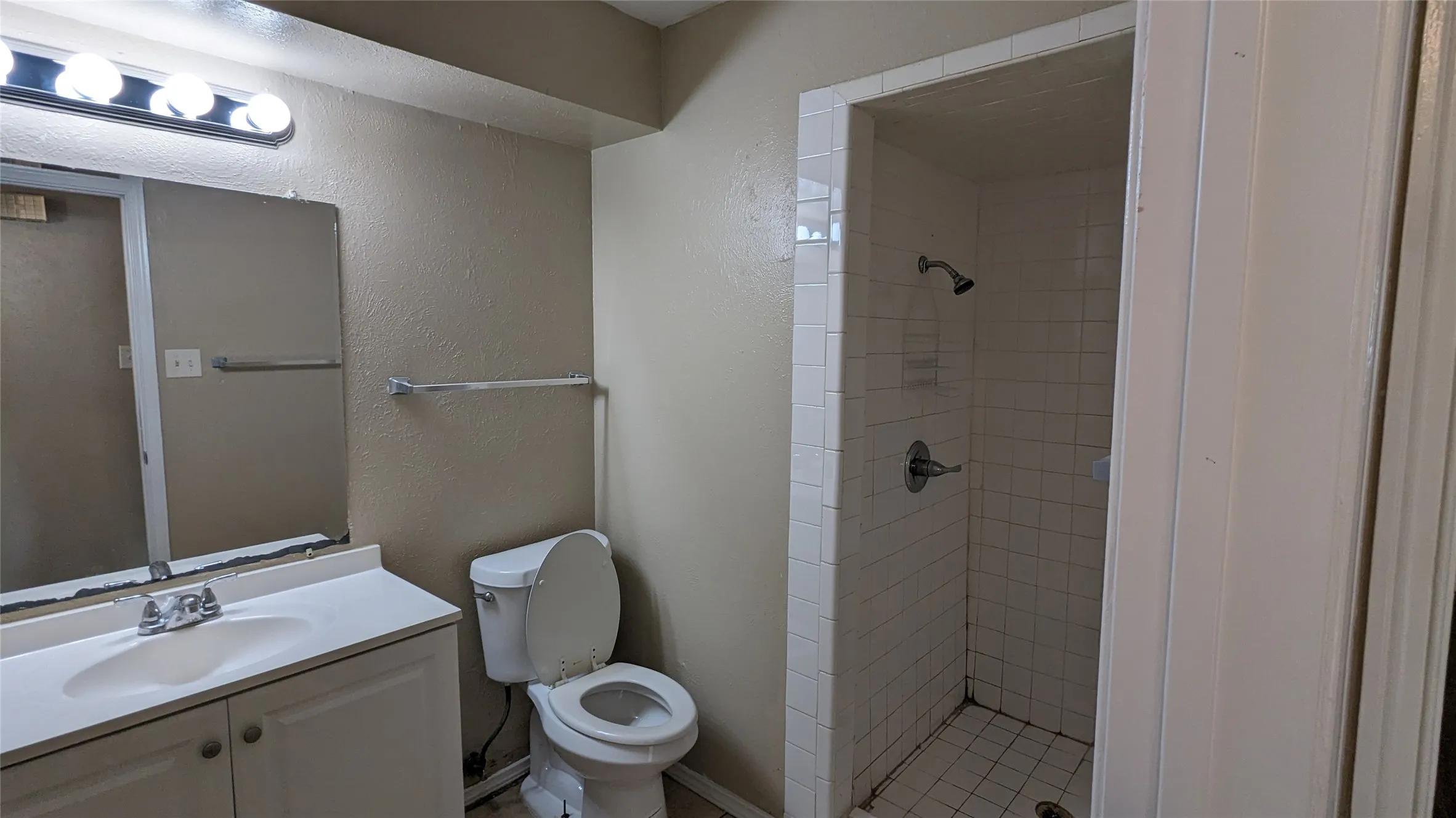 Bathroom featuring a white vanity with integrated sink, chrome faucet, and mirrored medicine cabinet
