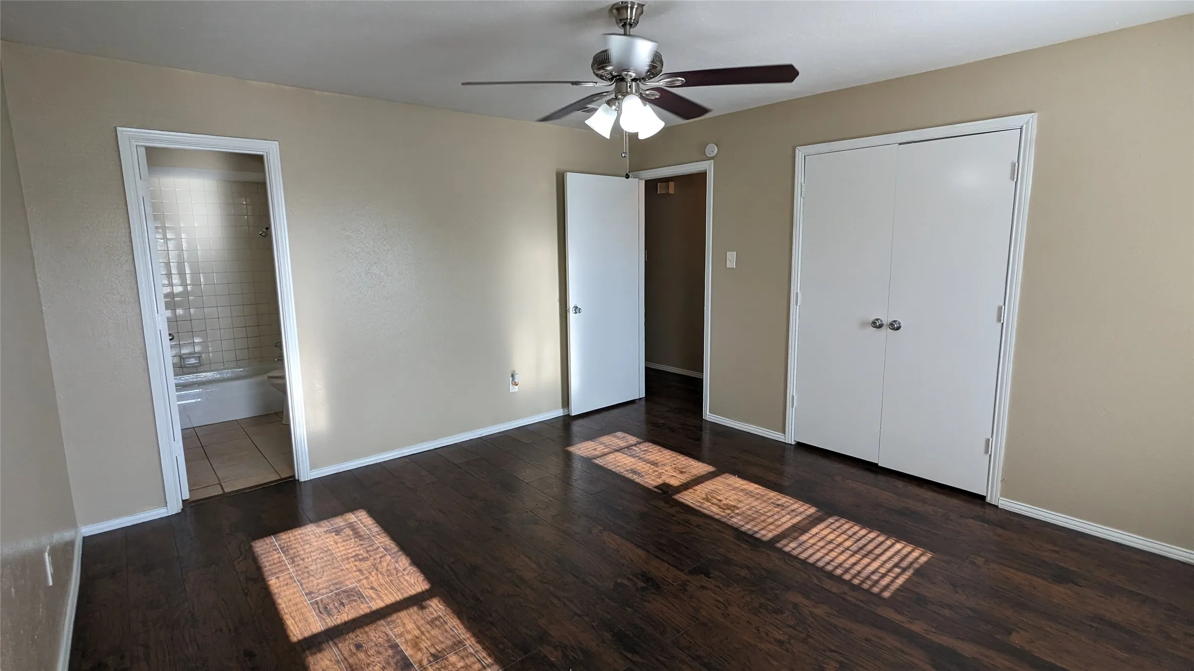 Room featuring wood-finish flooring, neutral wall tones, and a ceiling fan with integrated lighting