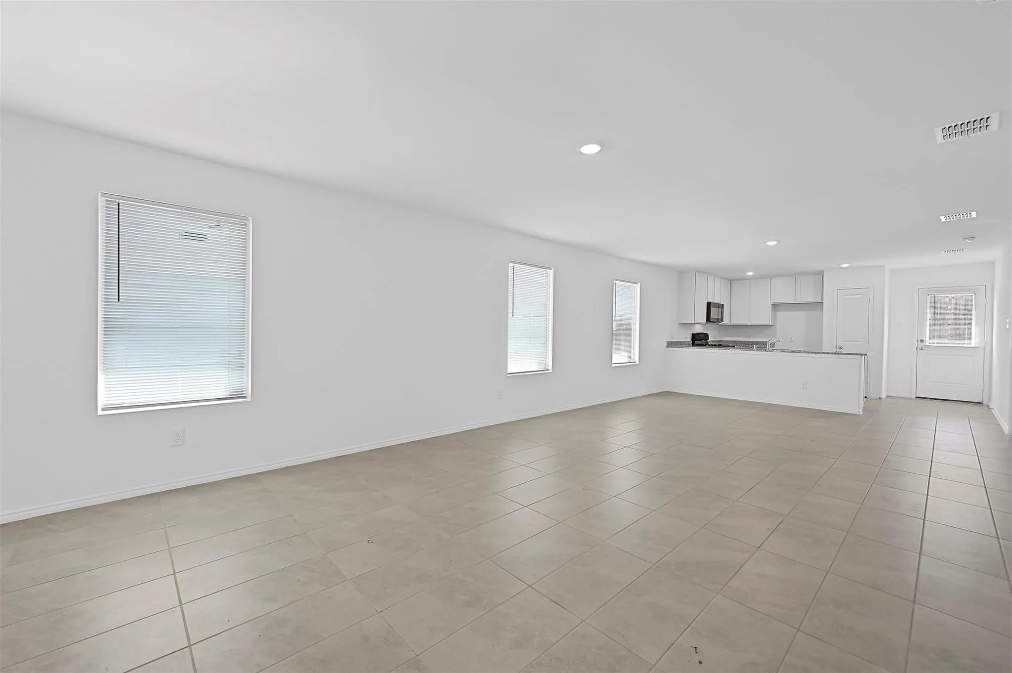 Another view of  living room with a healthy amount of sunlight and light tile floors