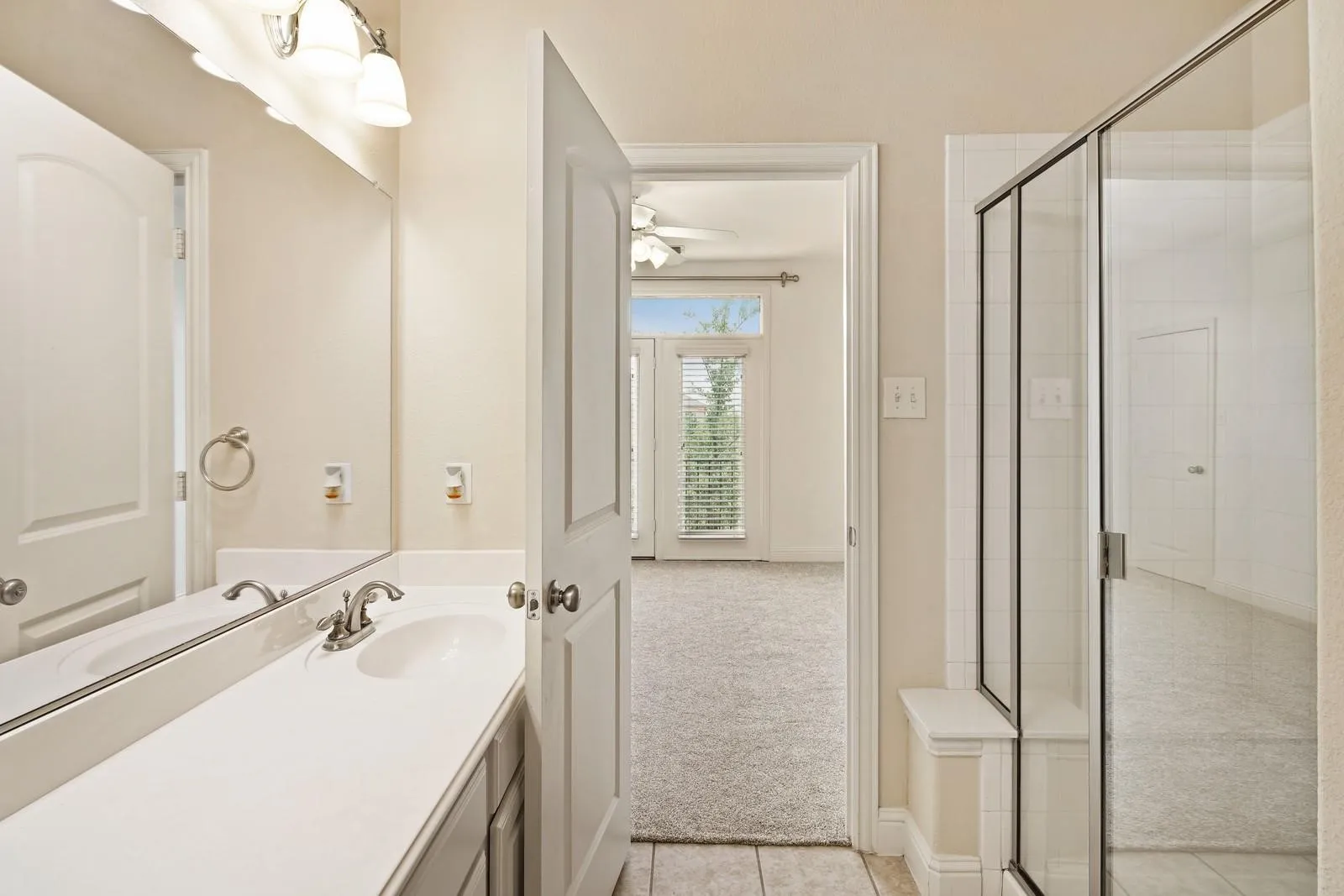 Bathroom featuring a single vanity with an integrated sink, brushed nickel faucet, and overhead three-bulb light fixture